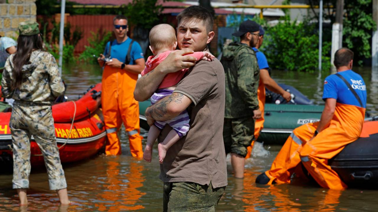 A man carries a child as members of Russia's emergencies ministry evacuate residents of a flooded area following the collapse of the Nova Kakhovka dam in Russian-controlled Kherson. /Alexander Ermochenko/Reuters