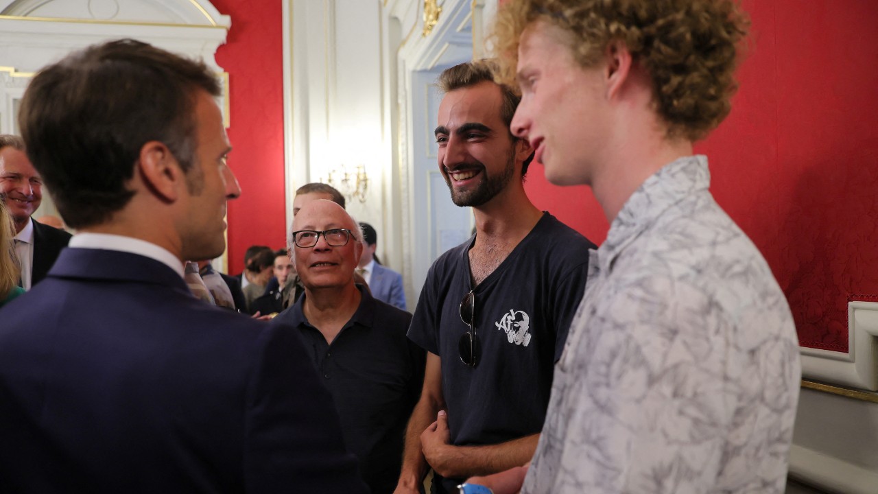 Macron meets 'backpack hero' Henri (center, bearded), his friend Lilian (r) and Youssouf (2nd l), who suffered minor stab wounds as he tried to intercept the suspect. /Denis Balibouse/Pool/Reuters