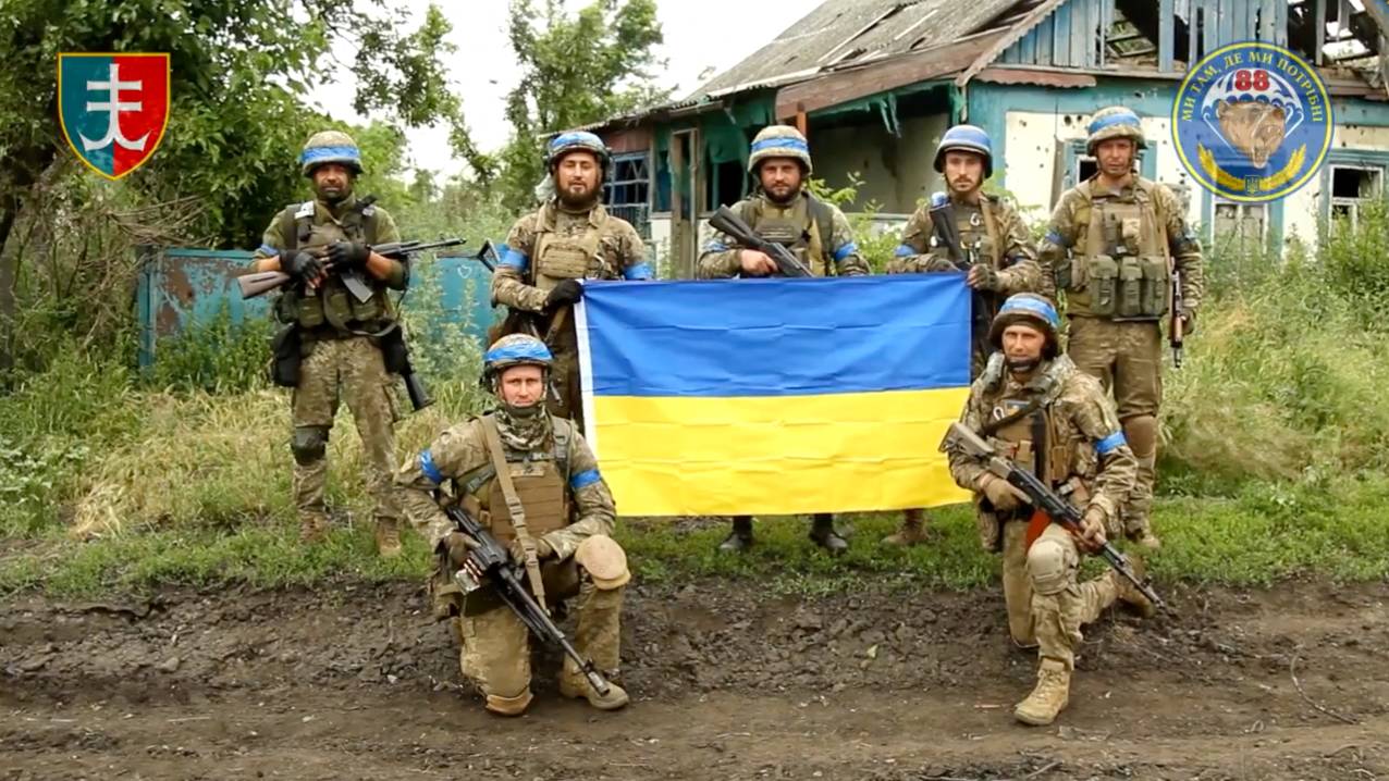 Ukrainian servicemen pose with the Ukrainian flag in the liberated village of Storozheve in Dontesk region. /35th Separate Brigade of Marines via Facebook/via Reuters