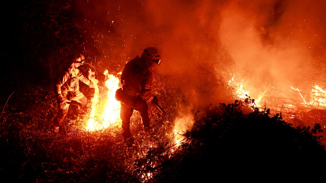 Firefighters tackle a forest fire after prolonged drought and a heatwave in Asturias, Spain, March 2023. /Vincent West/Reuters