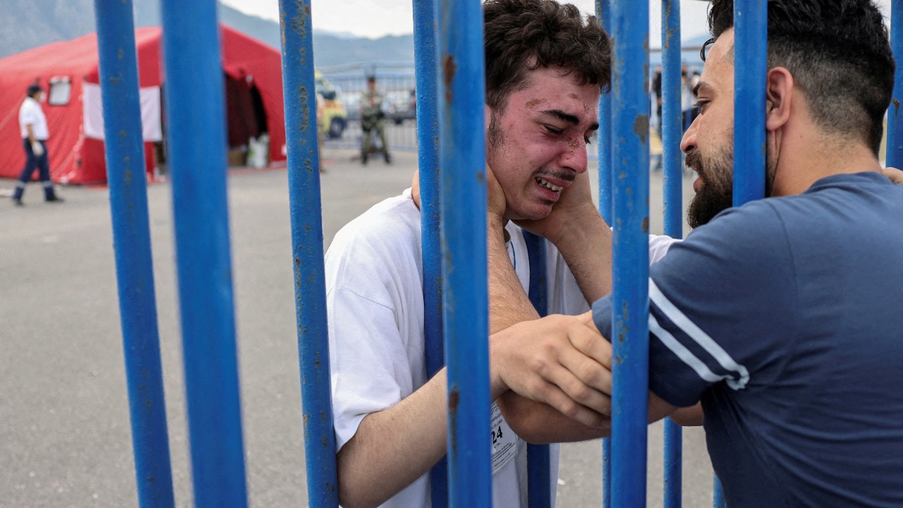 Syrian survivor Mohammad, 18, who was rescued with other refugees at open sea off Greece after their boat capsized, cries as he reunites with his brother Fadi, who came to meet him from Netherlands, at the port of Kalamata, Greece. /Stelios Misinas/Reuters