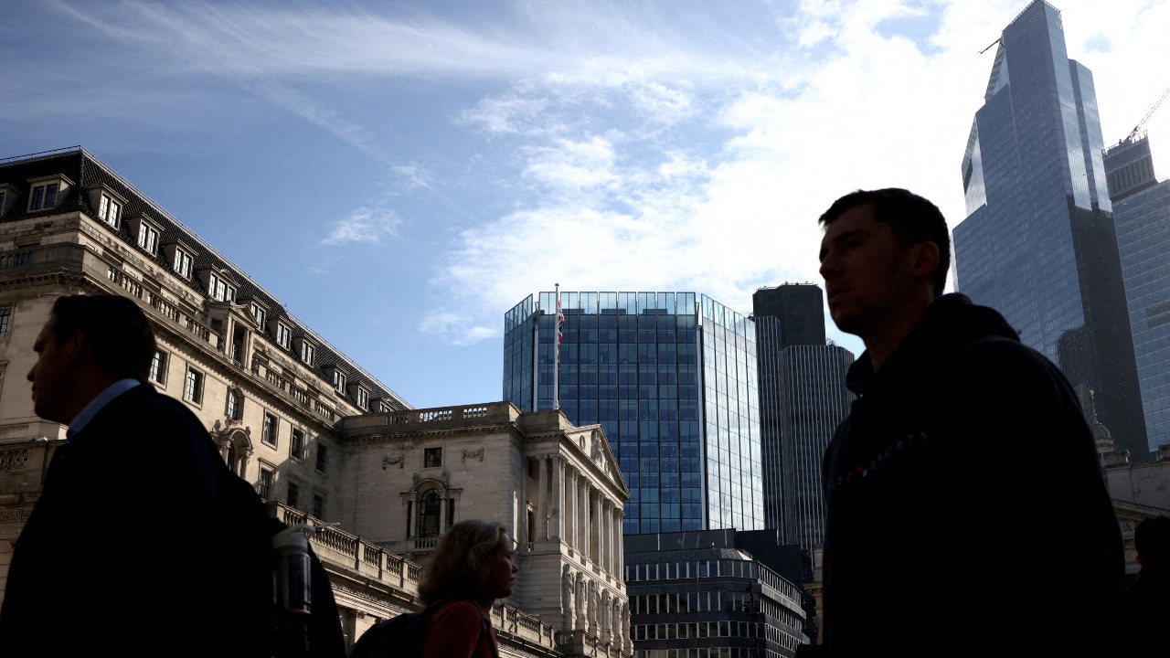 People walk outside the Bank of England in the City of London financial district in London, England. /Henry Nicholls/File photo/Reuters