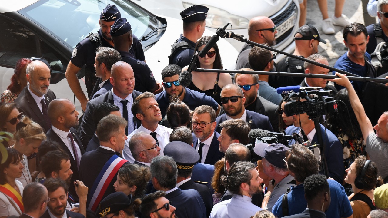 On his visit to Marseille, President Macron (center, in light shirt) has been vocal in his condemnation of the killing. /Nicolas Tucat/AFP