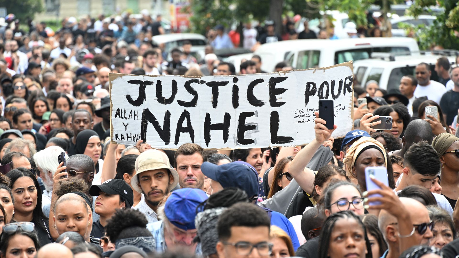 Attendees hold a banner reading 'Justice for Nahel' during a commemoration march. /Bertrand Guay 