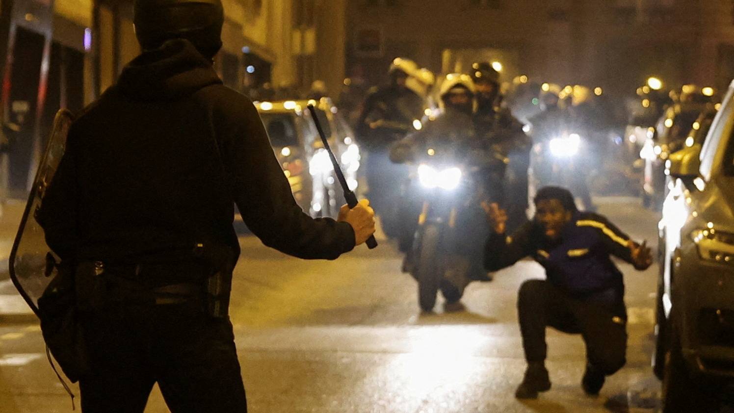 A police officer threatens a protester with a baton during protests in Paris. /Nacho Doce/Reuters