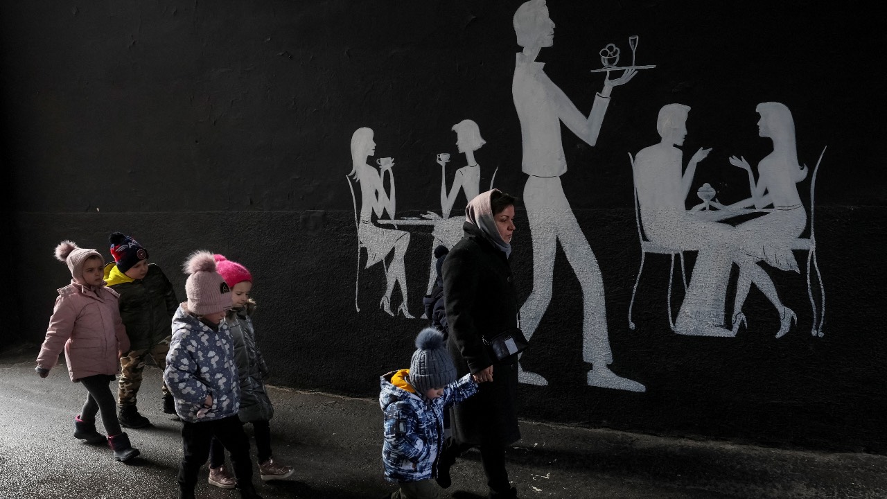 A kindergarten employee leads children to a bomb shelter during an air raid in central Kyiv. /Gleb Garanich/Reuters