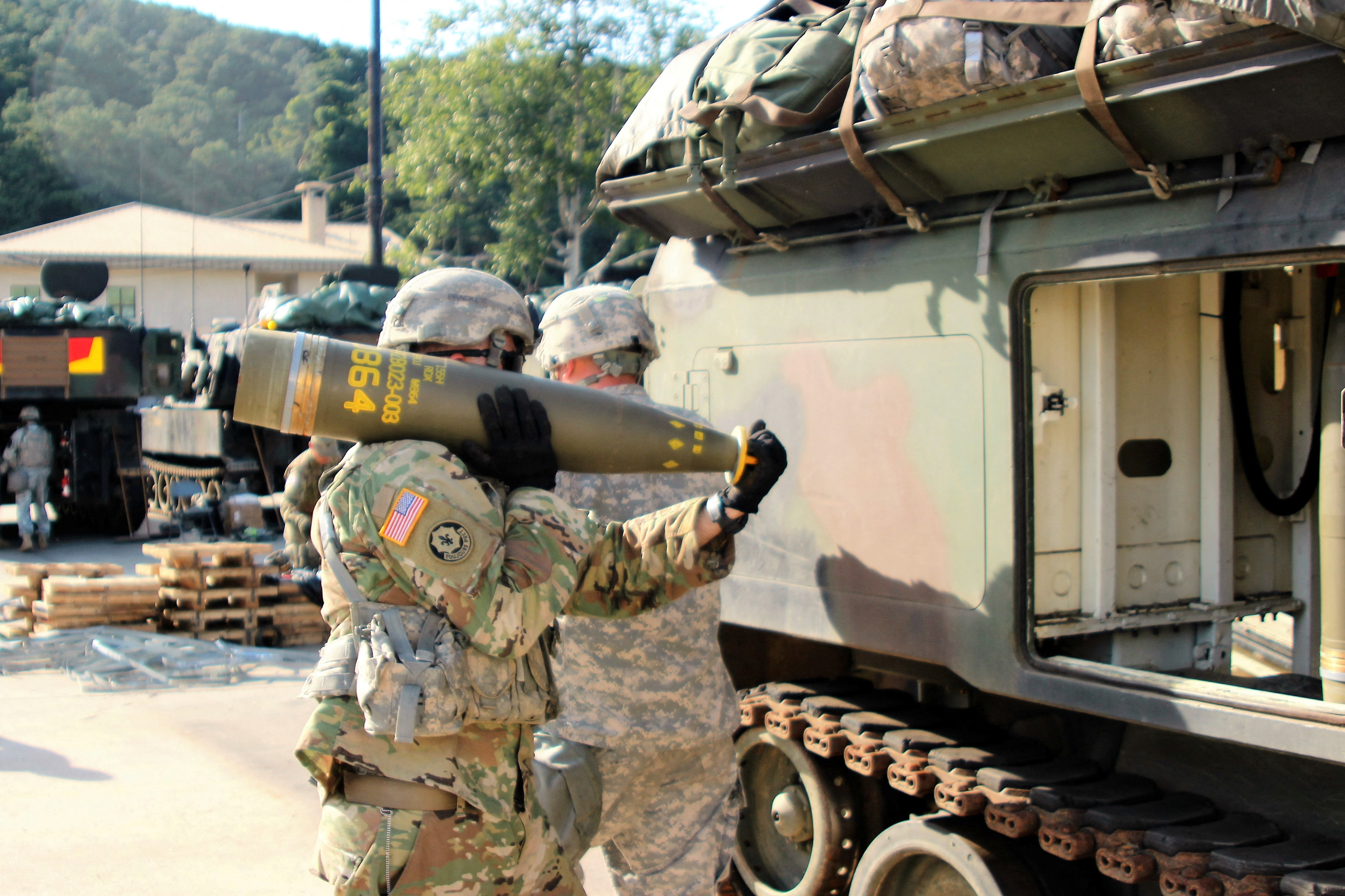 A U.S. Army soldier transfers a 155mm Base Burn Dual Purpose Improved Conventional Munition (DPICM) round into a vehicle. U.S. Army/2nd Lt. Gabriel Jenko/ Reuters