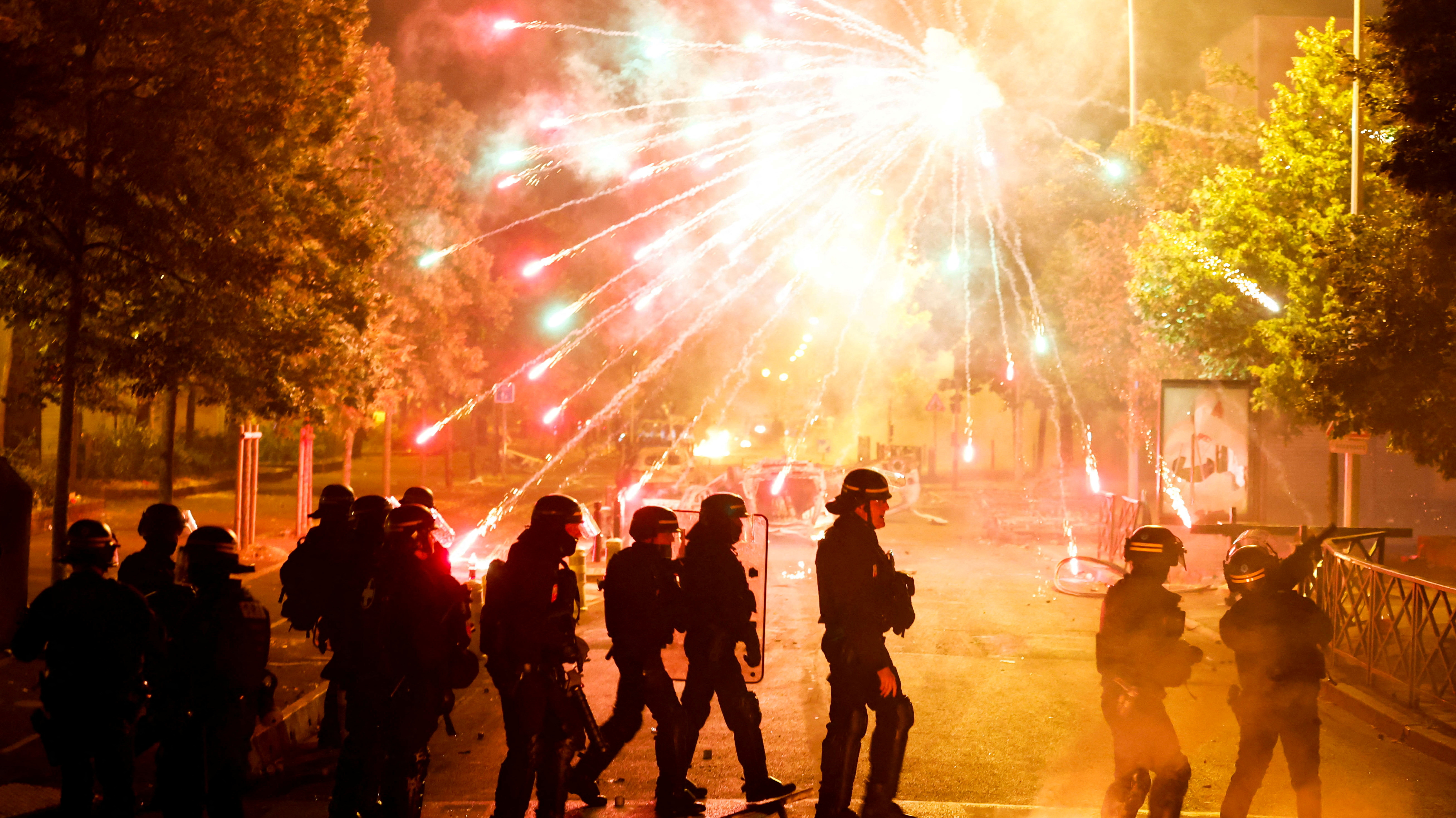 French police stand in position as fireworks go off during clashes after the death of a 17-year-old teenager in a Paris suburb. /Gonzalo Fuentes/Reuters
