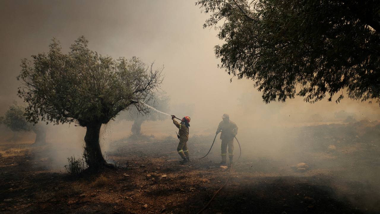 A firefighter tries to extinguish a wildfire burning near the village Vlyhada, near Athens. /Stelios Misinas.Reuters