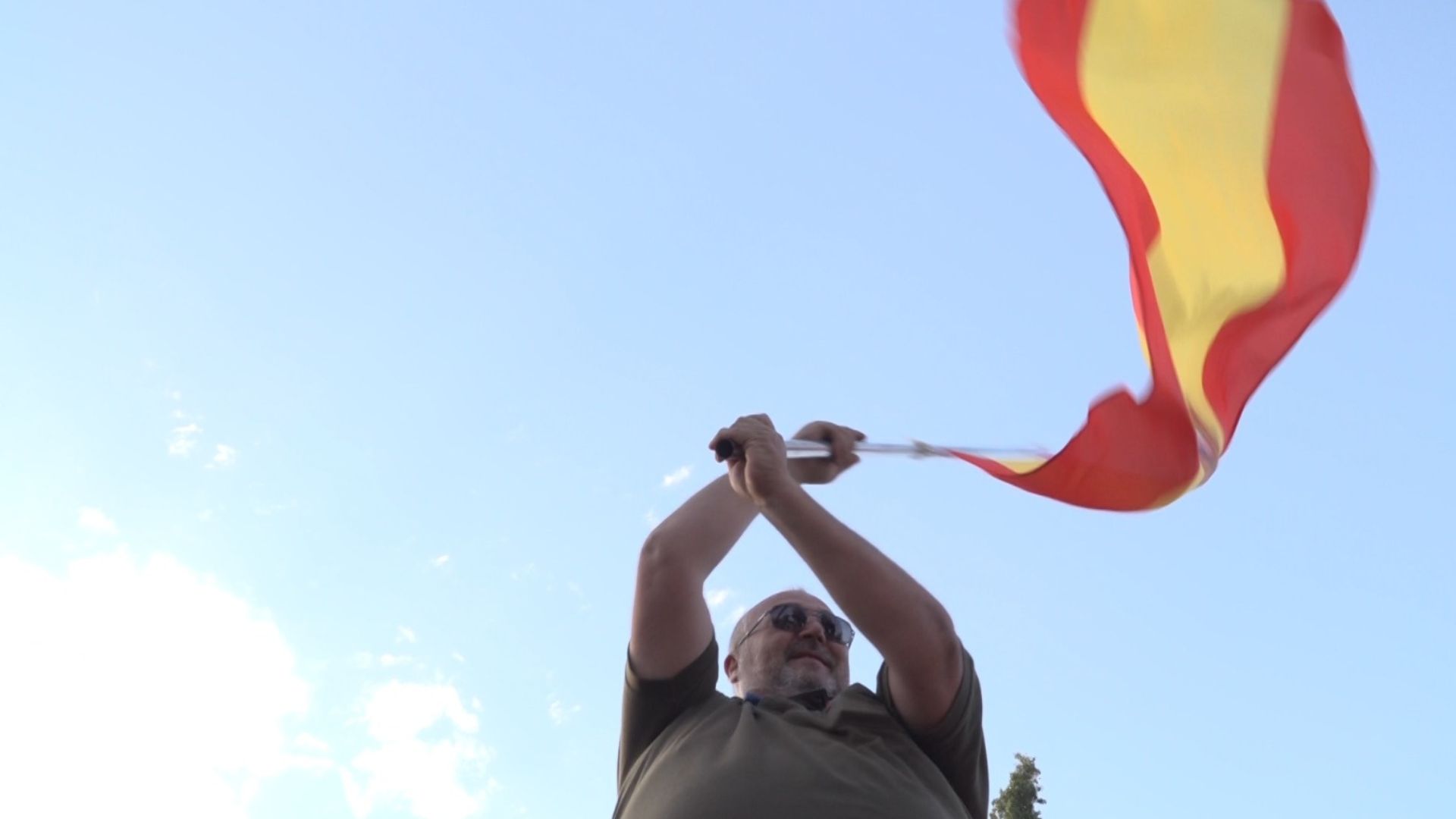 A nationalist Abascal supporter waves a Spanish flag at the rally. /CGTN