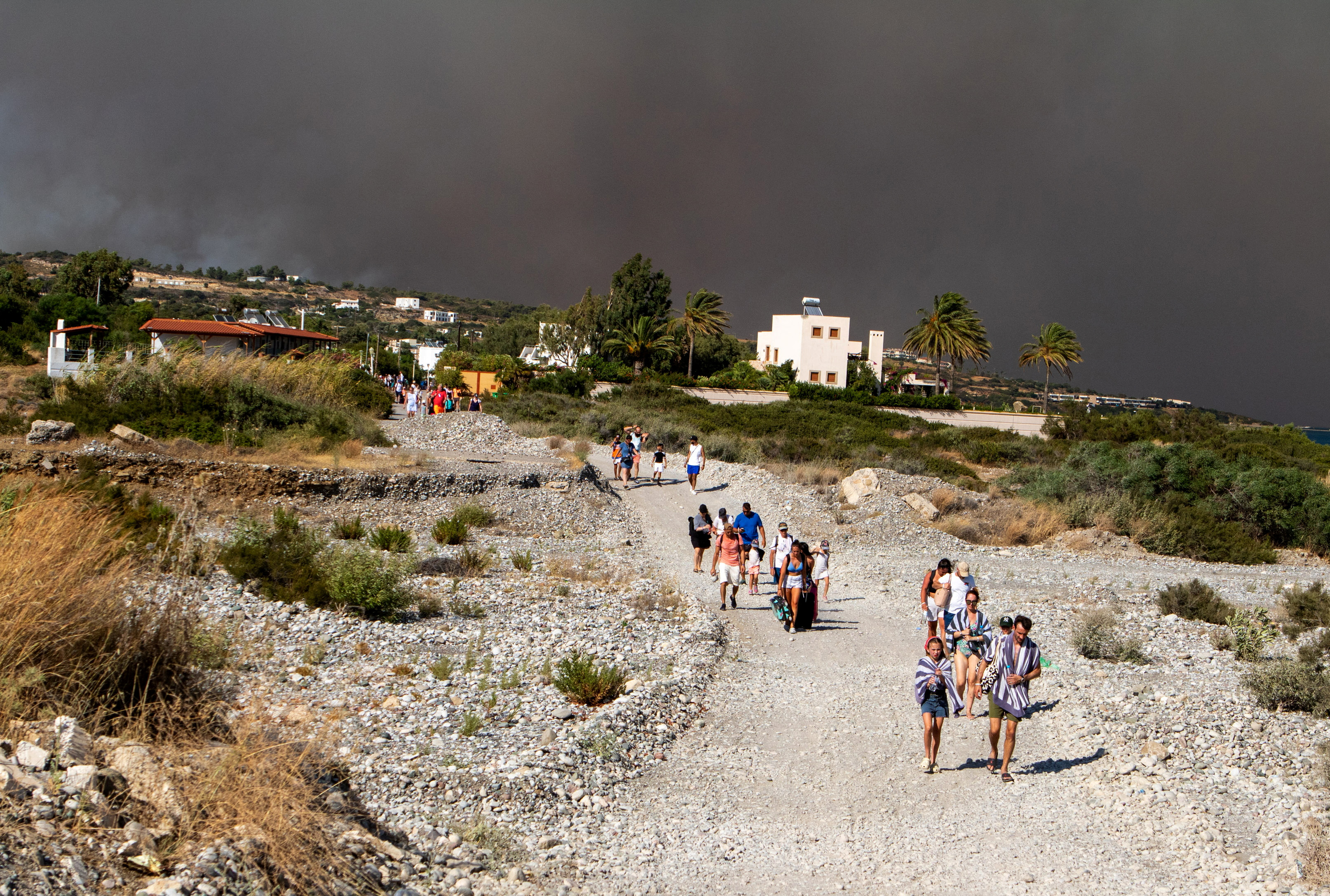 Tourists being evacuated as wildfire burn on the island of Rhodes. Lefteris Damianidis/ Reuters 