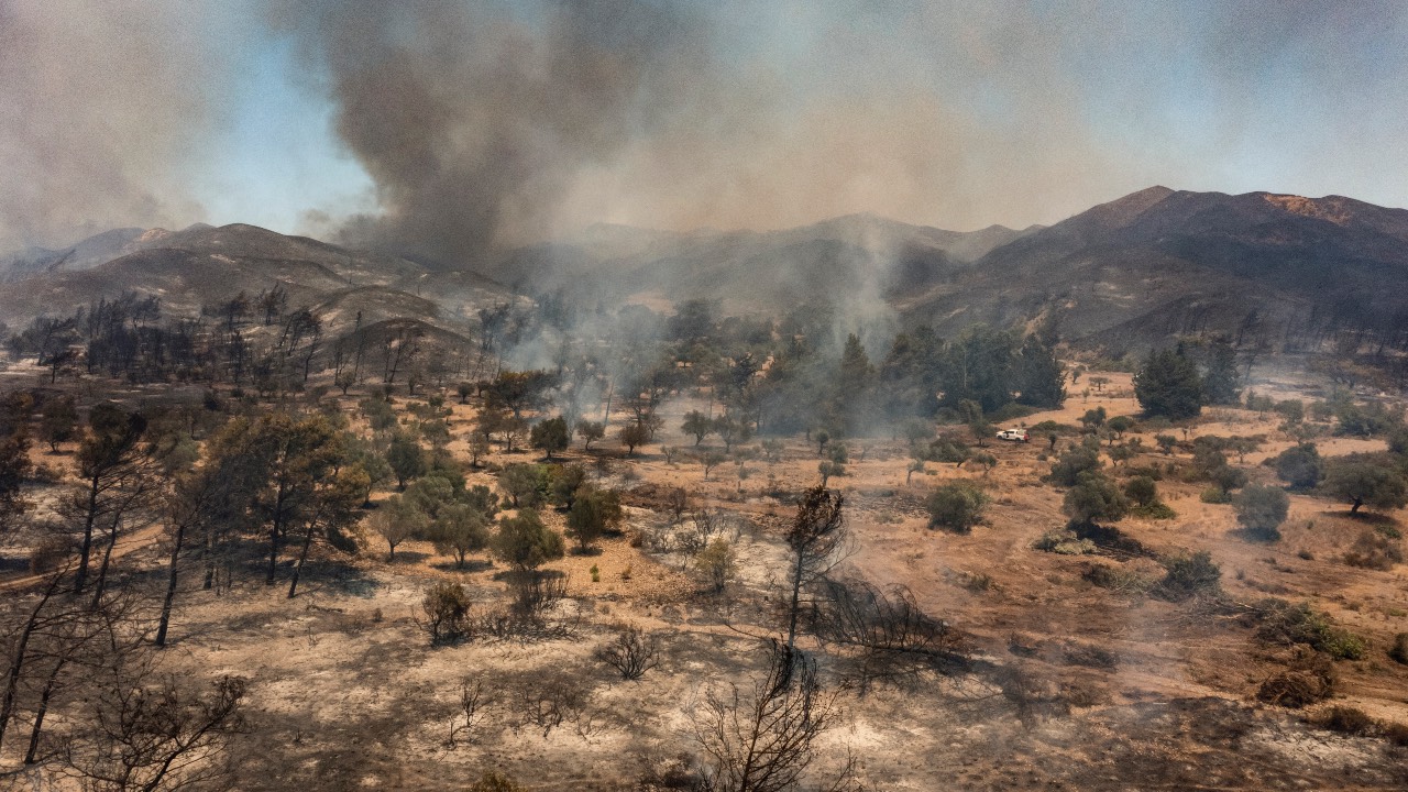 An aerial view shows wildfires burning a forest near the village of Vati, just north of the coastal town of Gennadi, in the southern part of the Greek island of Rhodes. /Spyros Bakalis/AFP