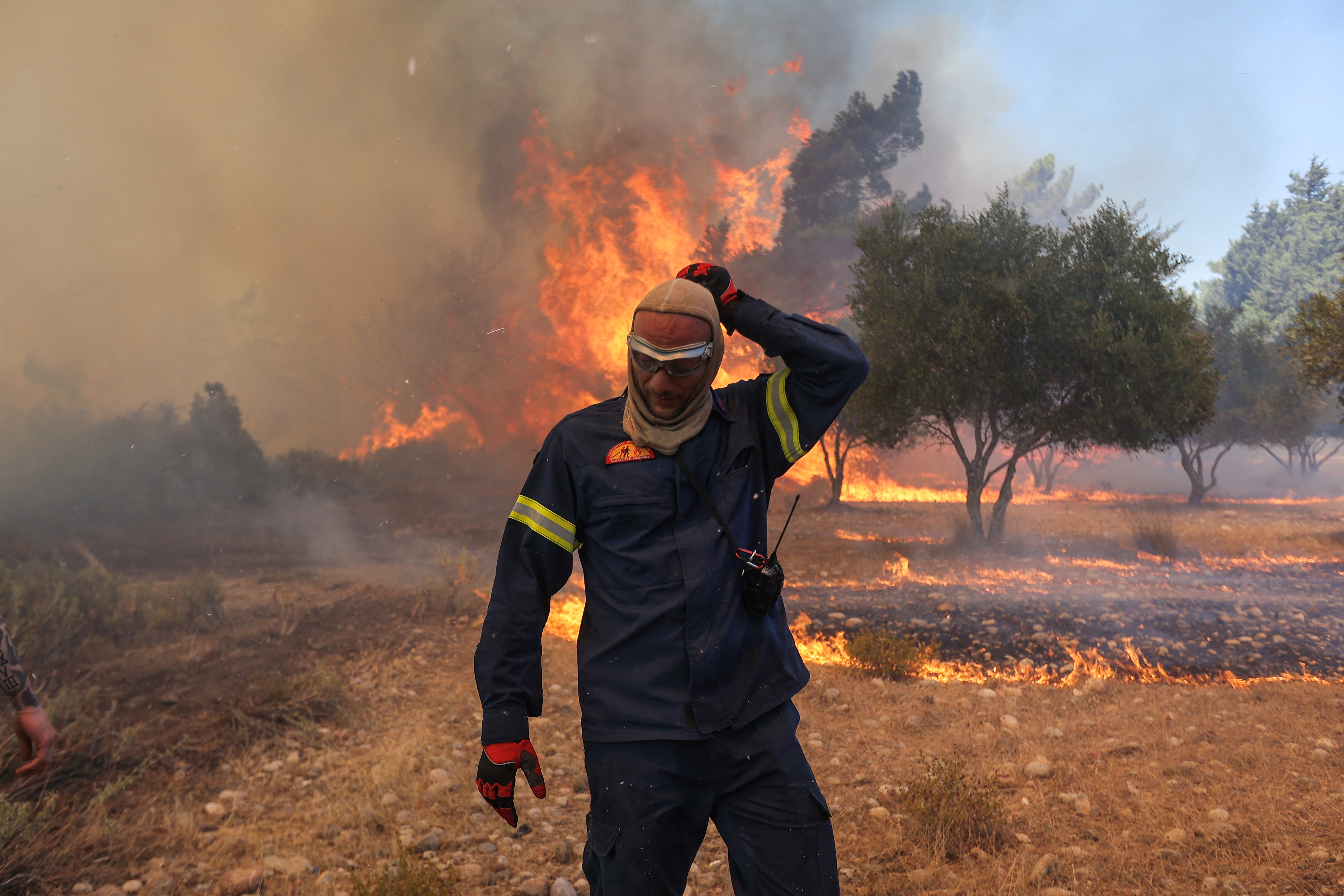 罗德岛瓦蒂村附近野火燃烧，一名消防员走在熊熊燃烧的火焰旁。  /尼古拉斯·伊科诺莫/路透社