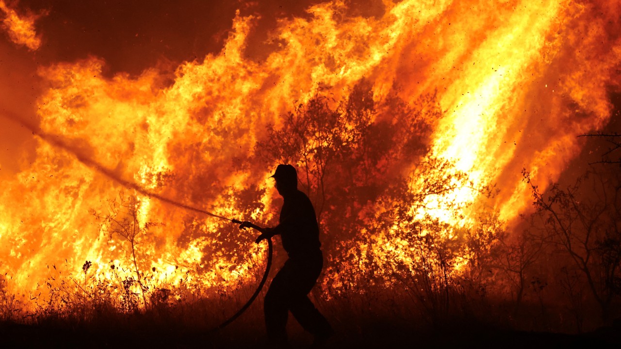 A firefighter tries to extinguish a wildfire burning at the industrial zone of the city of Volos, in central Greece. Alexandros Avramidis/Reuters