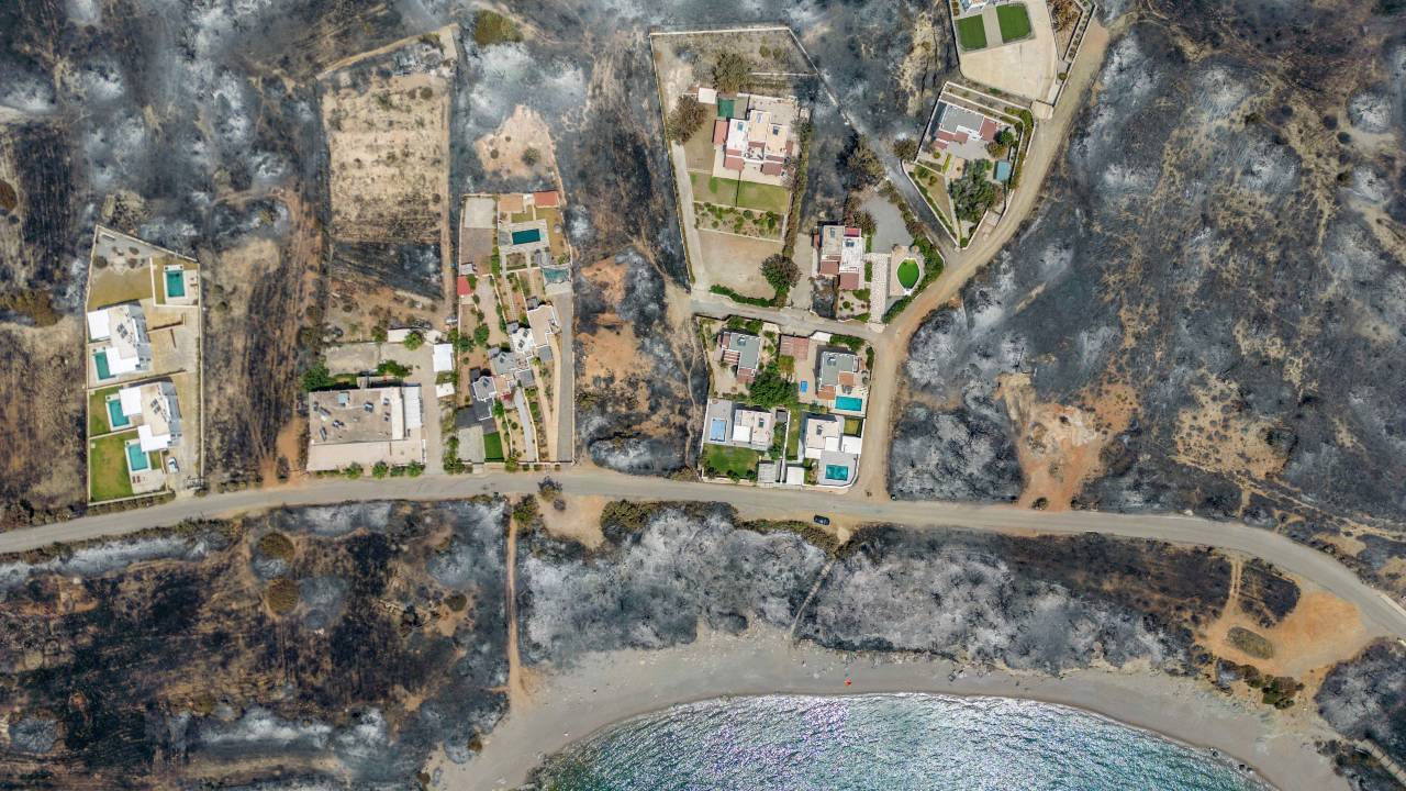 An aerial view of houses among burned land, as a wildfire burns on the island of Rhodes. /Nicolas Economou/Reuters