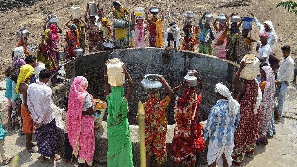 Indian women from the aboriginal Kol community collect drinking water at a well in Nawargawa village, some 30km from Jabalpur, in Madhya Pradesh state. /Uma Shankar Mishra/CFP