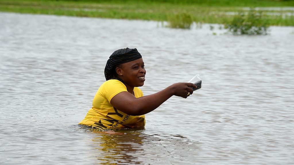 A woman walks in a flooded road following heavy rain downpour at Wawa in Ogun State southwest Nigeria. /Pius Utomi Ekpei/CFP