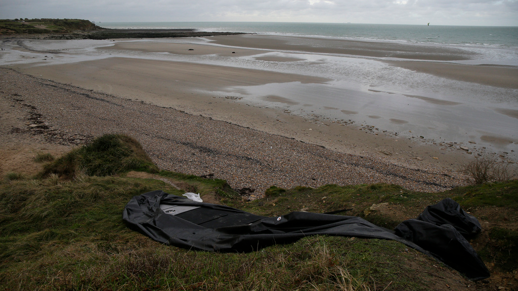 A deflated boat lies on the shore in northern France. /AP