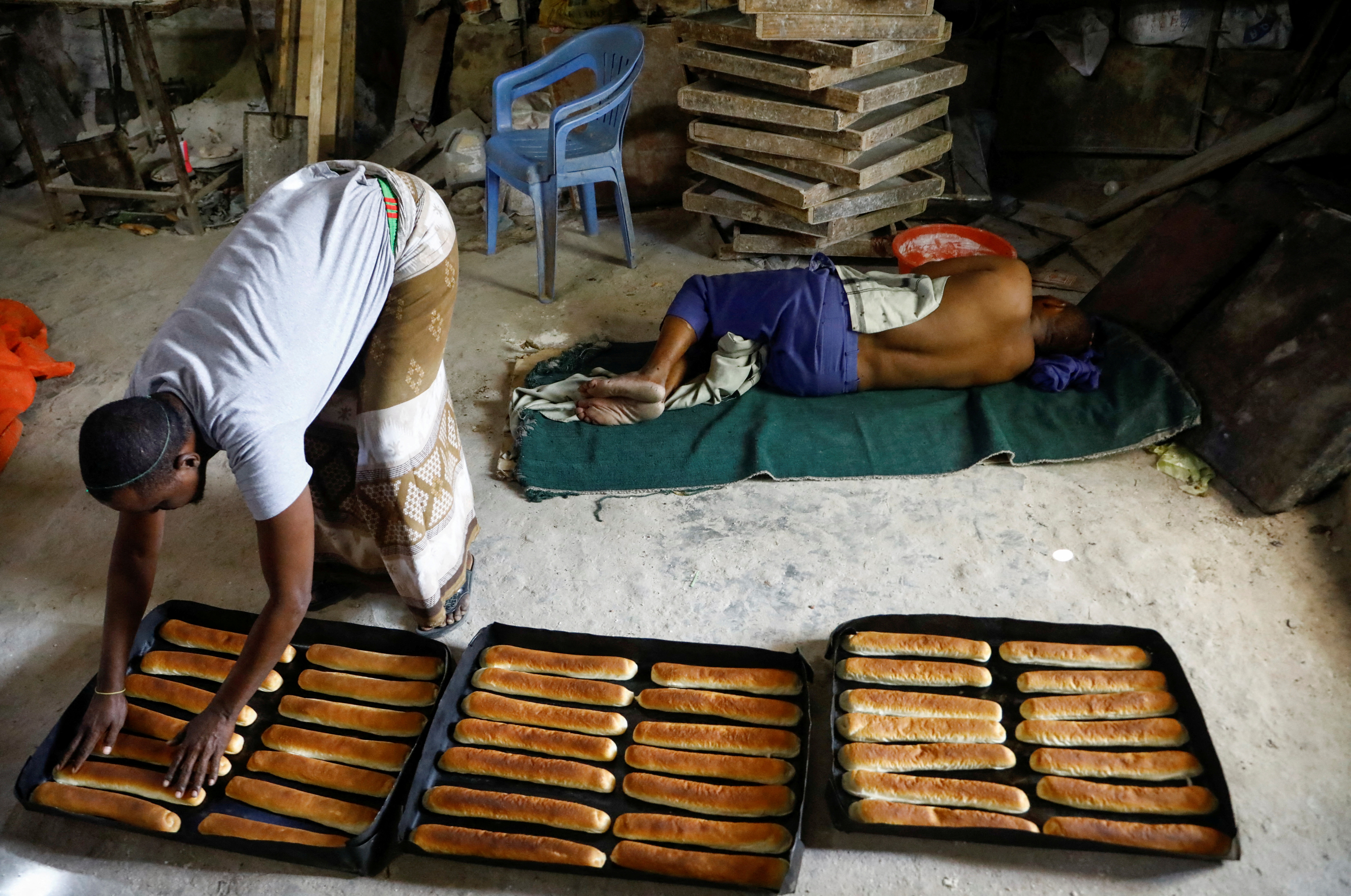 A worker prepares baked goods with wheat from Ukraine as his colleague rests at a bakery, in Hodan district in Mogadishu, Somalia July 16, 2023. REUTERS/Feisal Omar