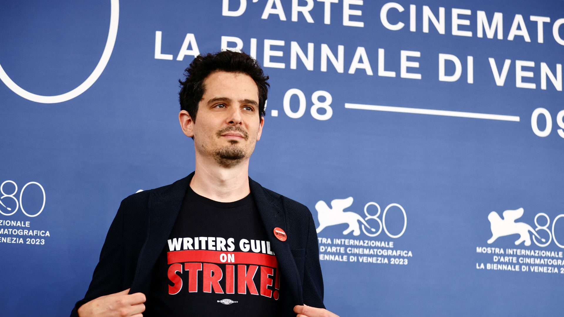 Venezia 80 Competition Jury President Damien Chazelle poses in a t-shirt backing the strike. /Yara Nardi/Reuters
