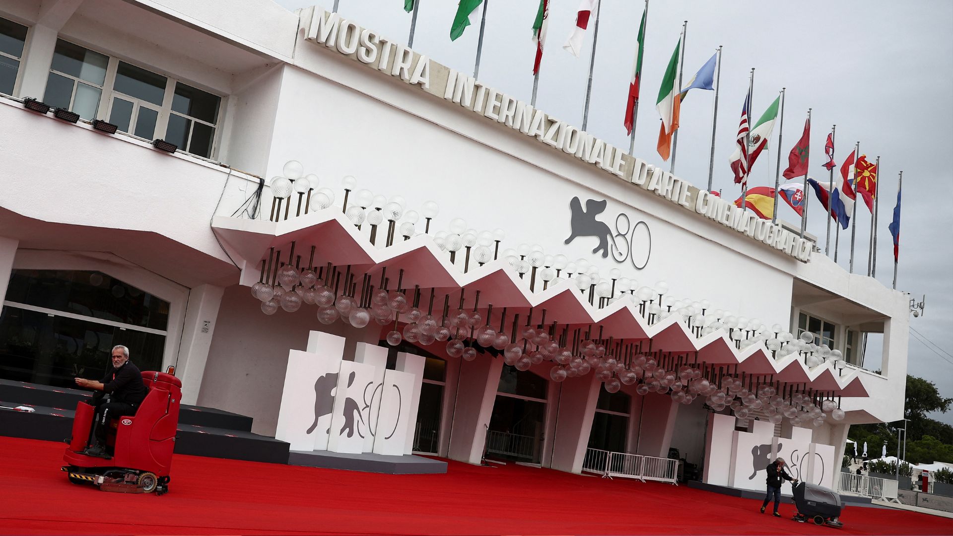 Workers clean the red carpet in front of the Palazzo del Cinema ahead of the festival's opening ceremony. /Guglielmo Mangiapane/Reuters