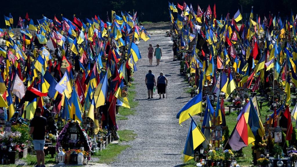 People walk through the cemetery of Lychakiv as they pay tribute to Ukraine's fallen soldiers in Lviv. /Yuriy Dyachshyn/AFP