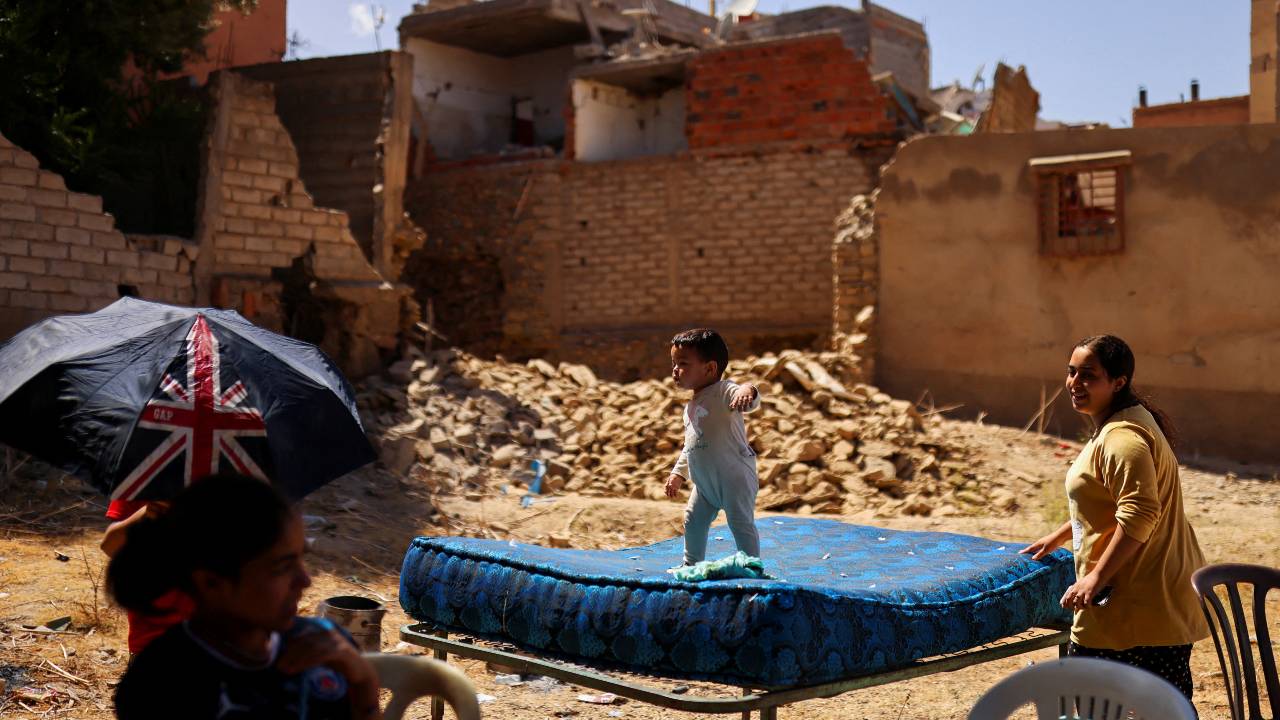 Hiba looks on as her daughter Sei eddine, two years old, plays on the mattress, in the aftermath of a deadly earthquake in Amizmiz. /Nacho Doce/Reuters