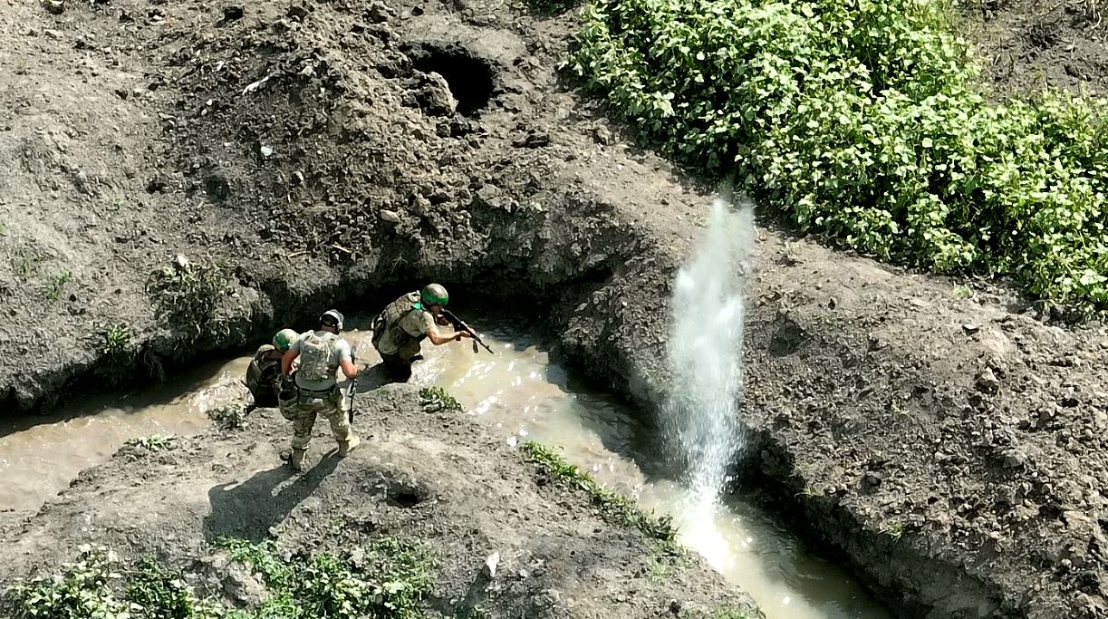 A live explosion detonates in the water near two Ukrainian soldiers. All of the trainee troops are civilians with no combat experience, who are being taught the basics of battle by experienced soldiers./CGTN.