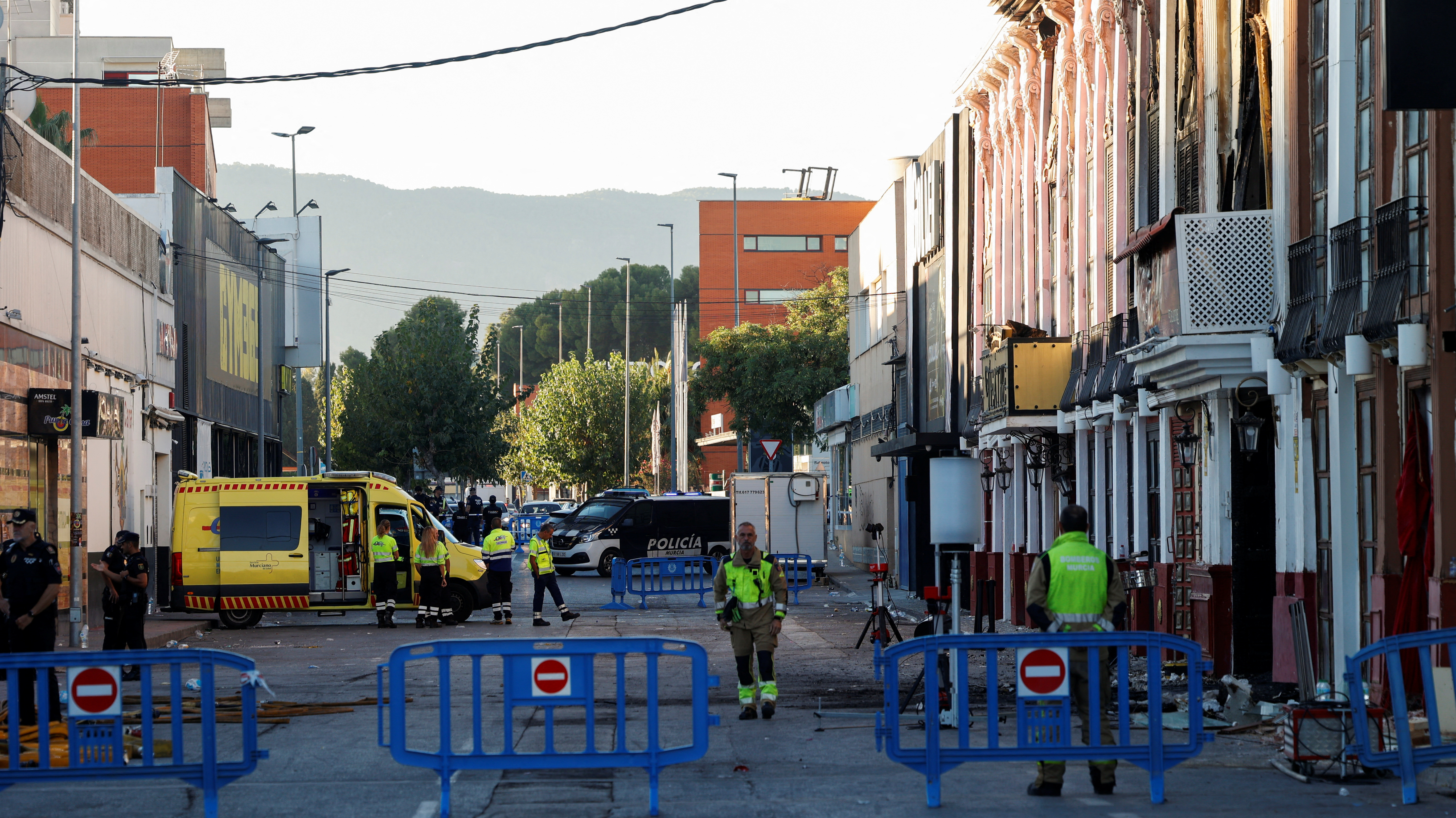 Firefighters outside adjoining nightclubs that caught fire in Murcia. /Eva Manez/Reuters