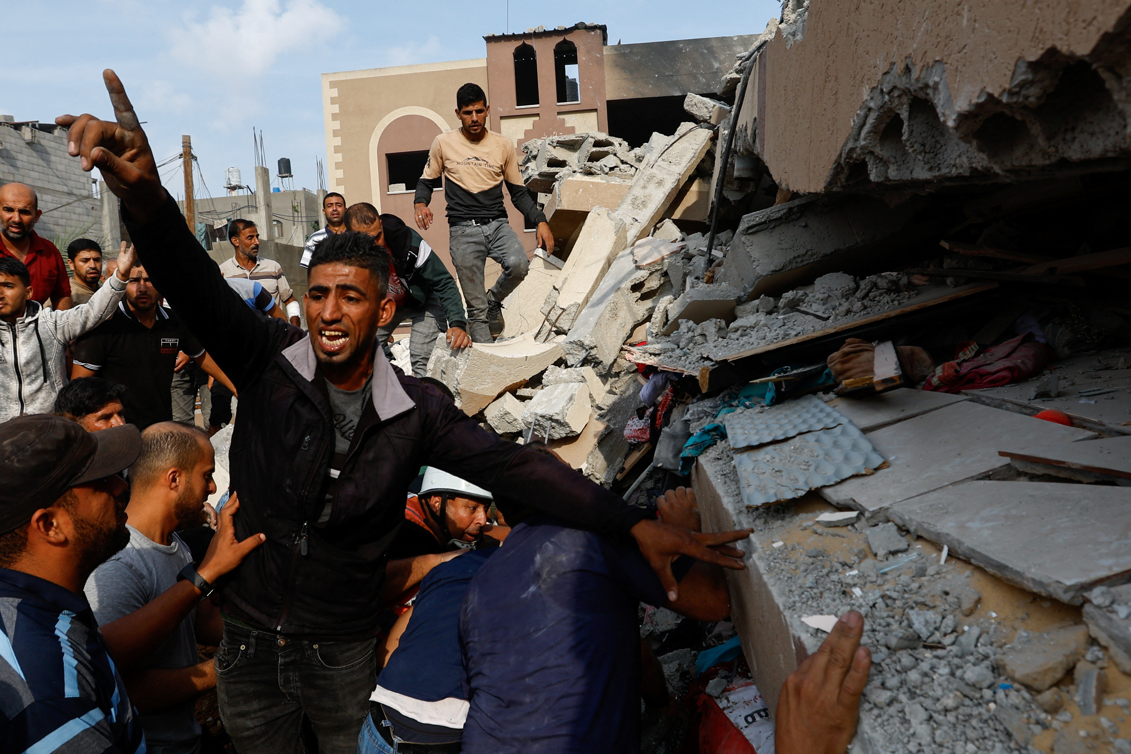 Palestinians search through the rubble of a house destroyed in Israeli strikes in Khan Younis, in the southern Gaza Strip. Ibraheem Abu Mustafa/ Reuters