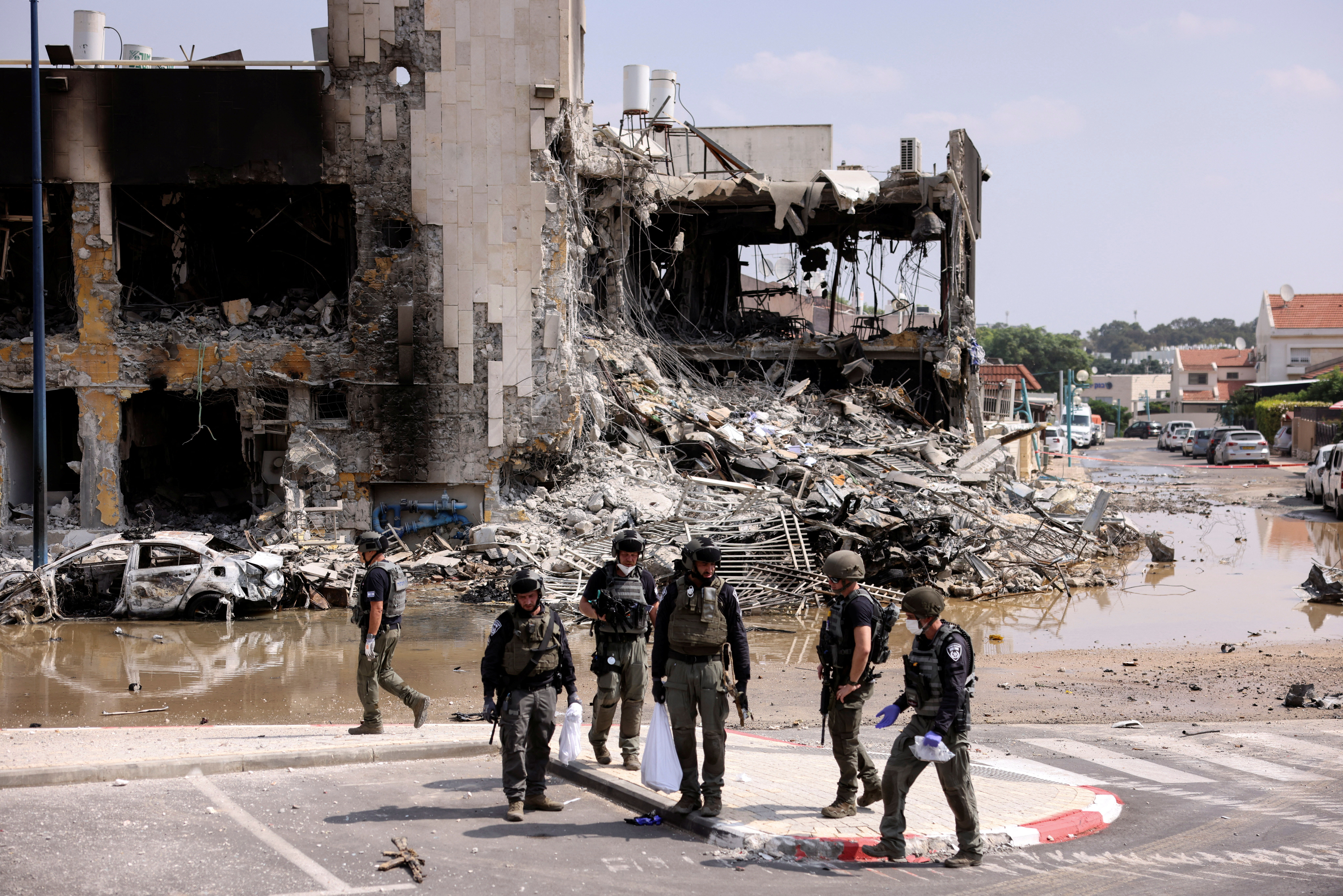 Israeli security gather near a rifle at the site of a battle with Hamas gunmen from the Gaza Strip, in Sderot. /Ronen Zvulun/ Reuters