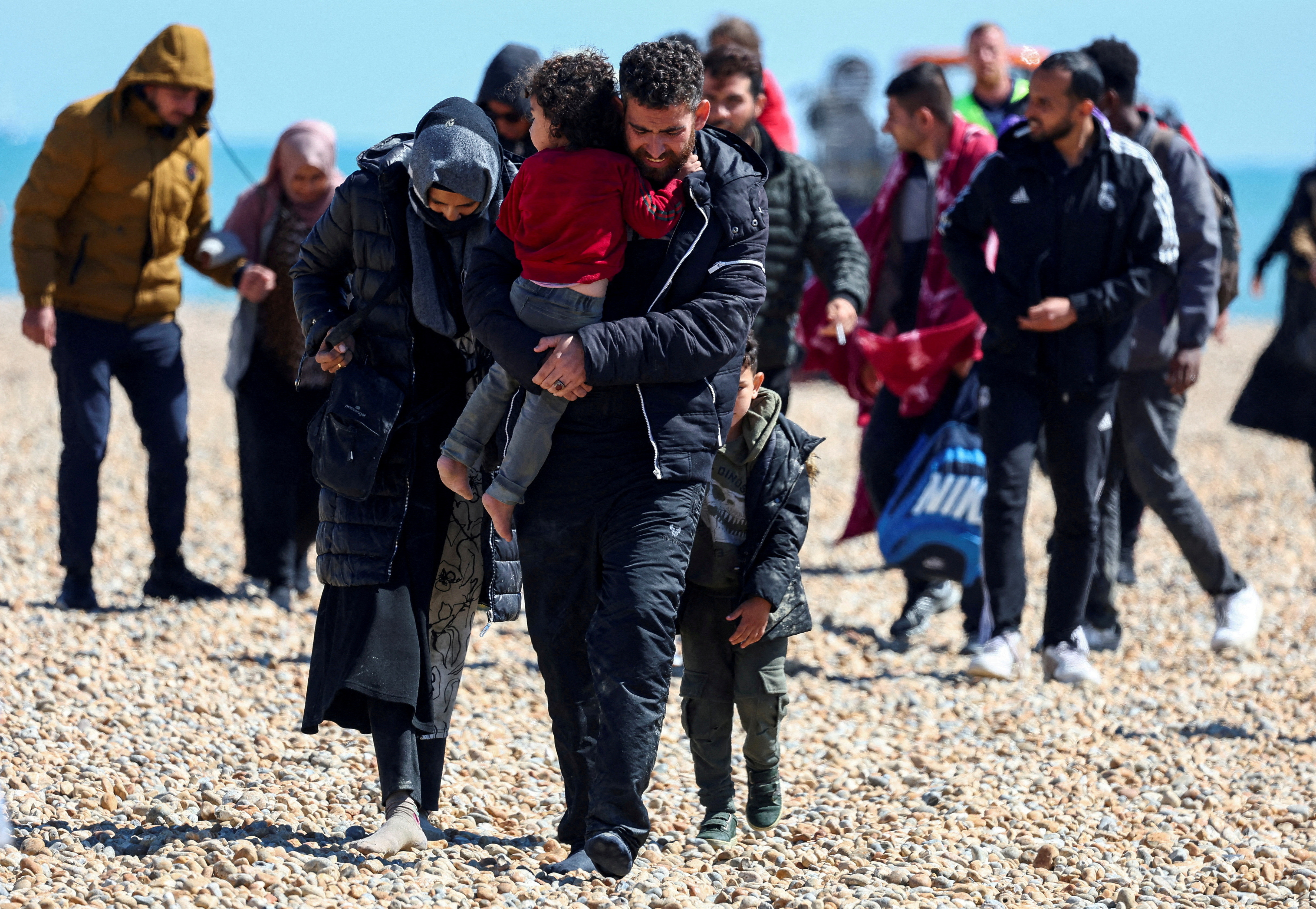 People, believed to be migrants, walk in Dungeness, Britain, on August 16, 2023. /Toby Melville/Reuters
