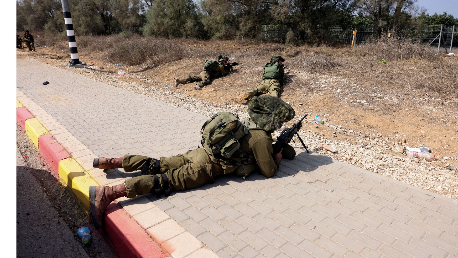 Israeli soldiers take position by the entrance to Kibbutz Kfar Aza, in southern Israel, which was raided by Hamas. /Ronen Zvulun/Reuters