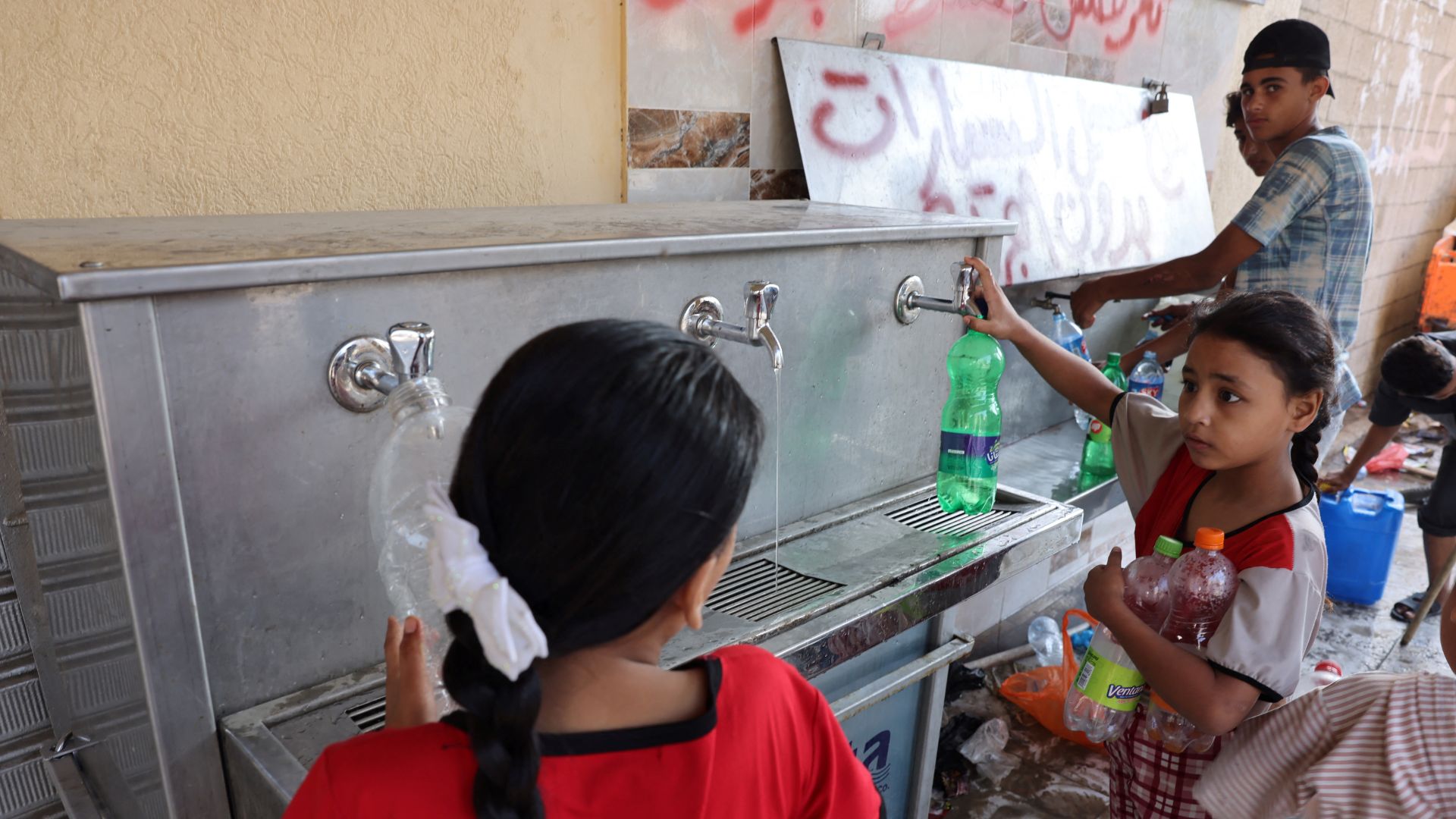 Children collect water from a public water collection point in Gaza city. /Mohammed Abed/AFP