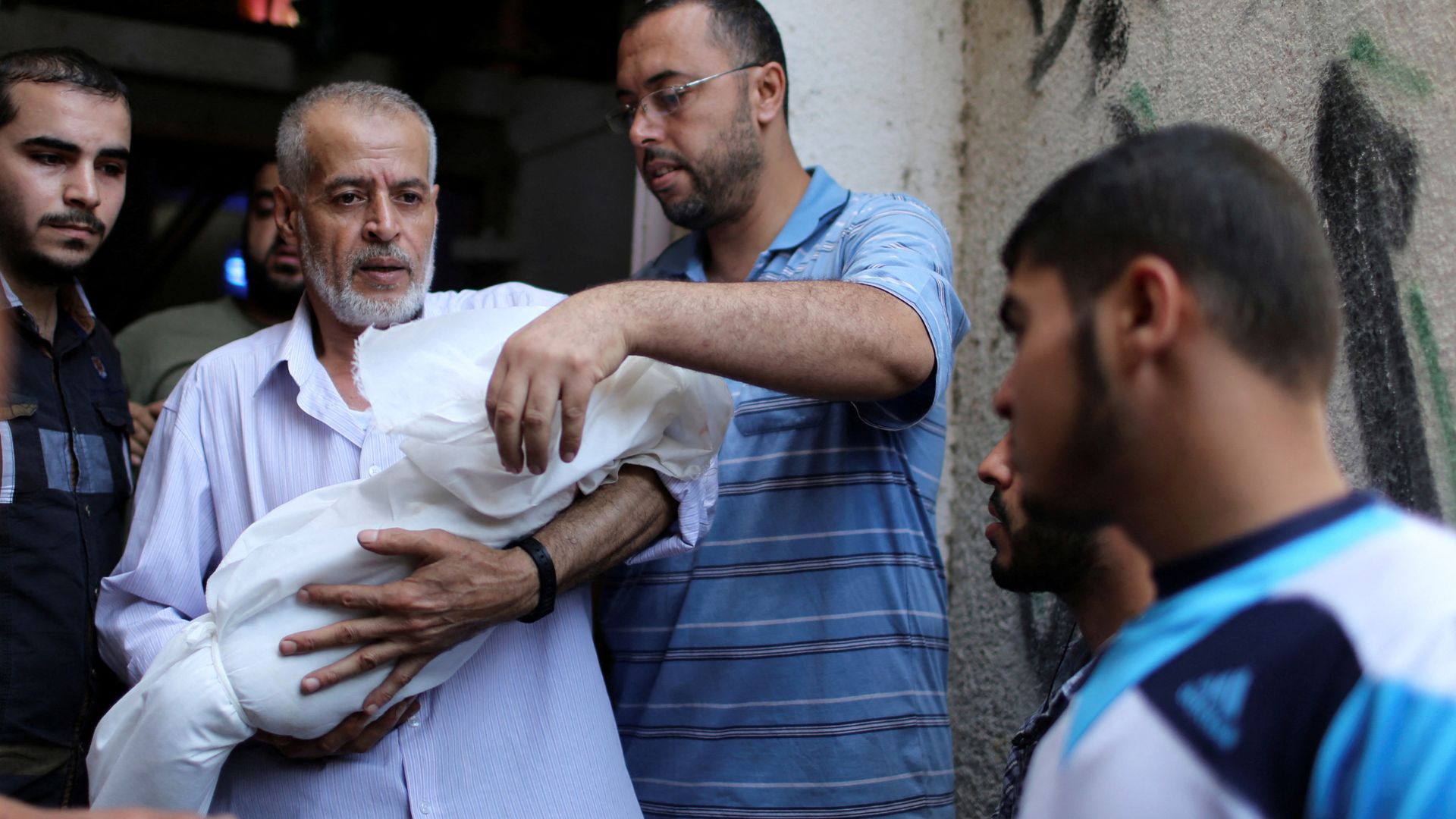 Deif's wife and son Ali – whose body is seen here carried by a relative – were killed in Israeli airstrikes in 2014. /Mohammed Salem/Reuters