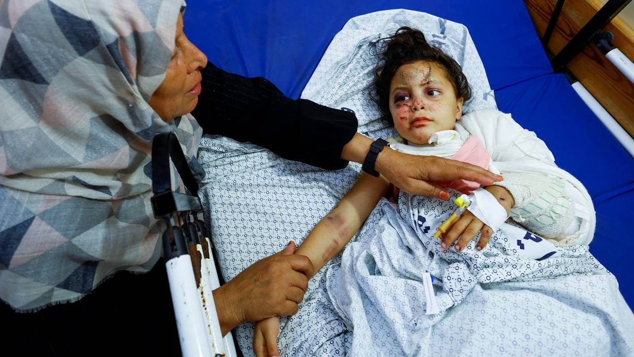 Palestinian girl Fulla Al-Laham, 4, who was wounded in an Israeli strike that killed 14 family members, including her parents and all her siblings, lies on a bed as her grandmother sits next to her at a hospital in the southern Gaza. /Mohammed Salem/Reuters