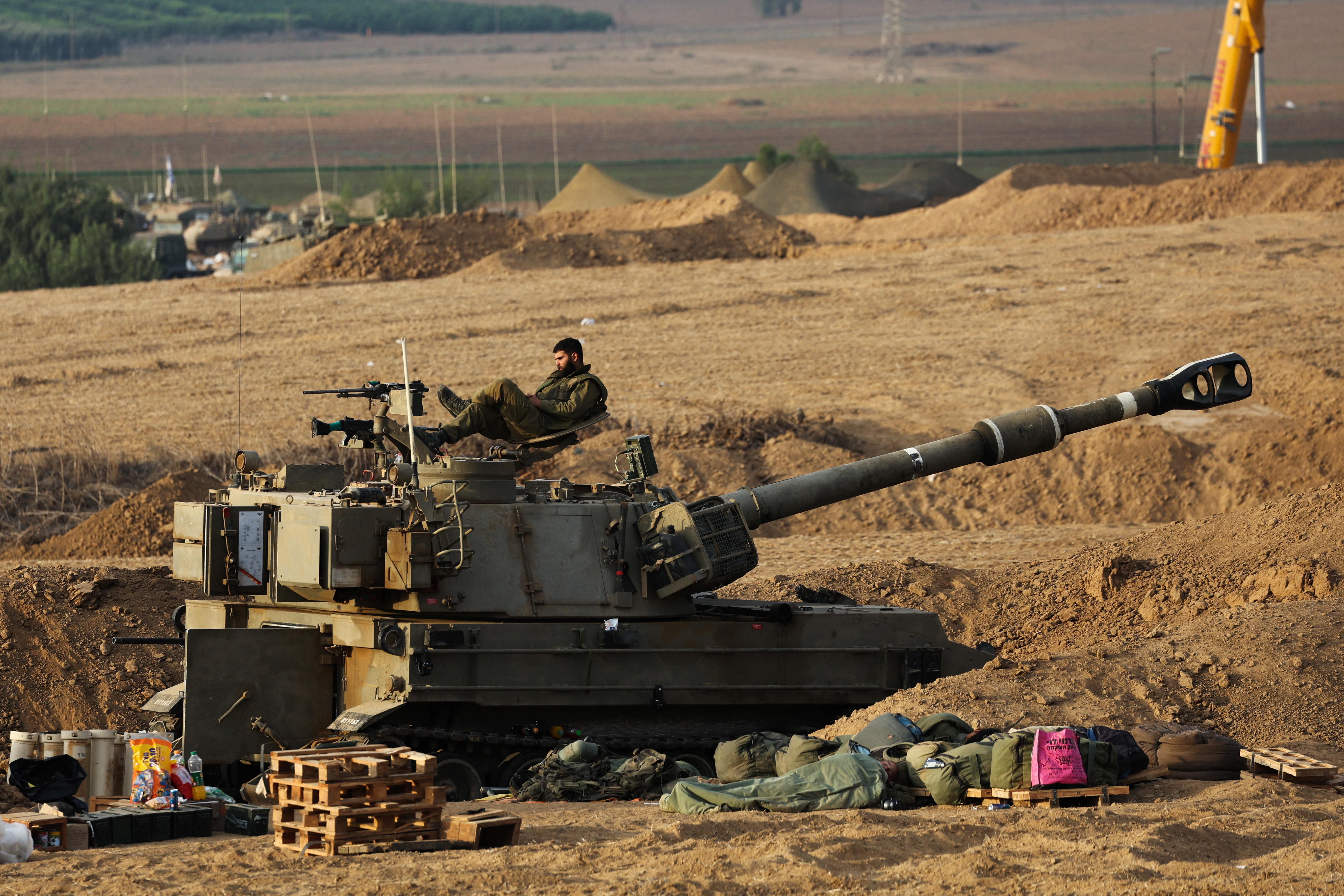 An Israeli sits on a self-propelled howitzer during the early morning near Israel's border with the Gaza Strip. /Violeta Santos Moura/Reuters.
