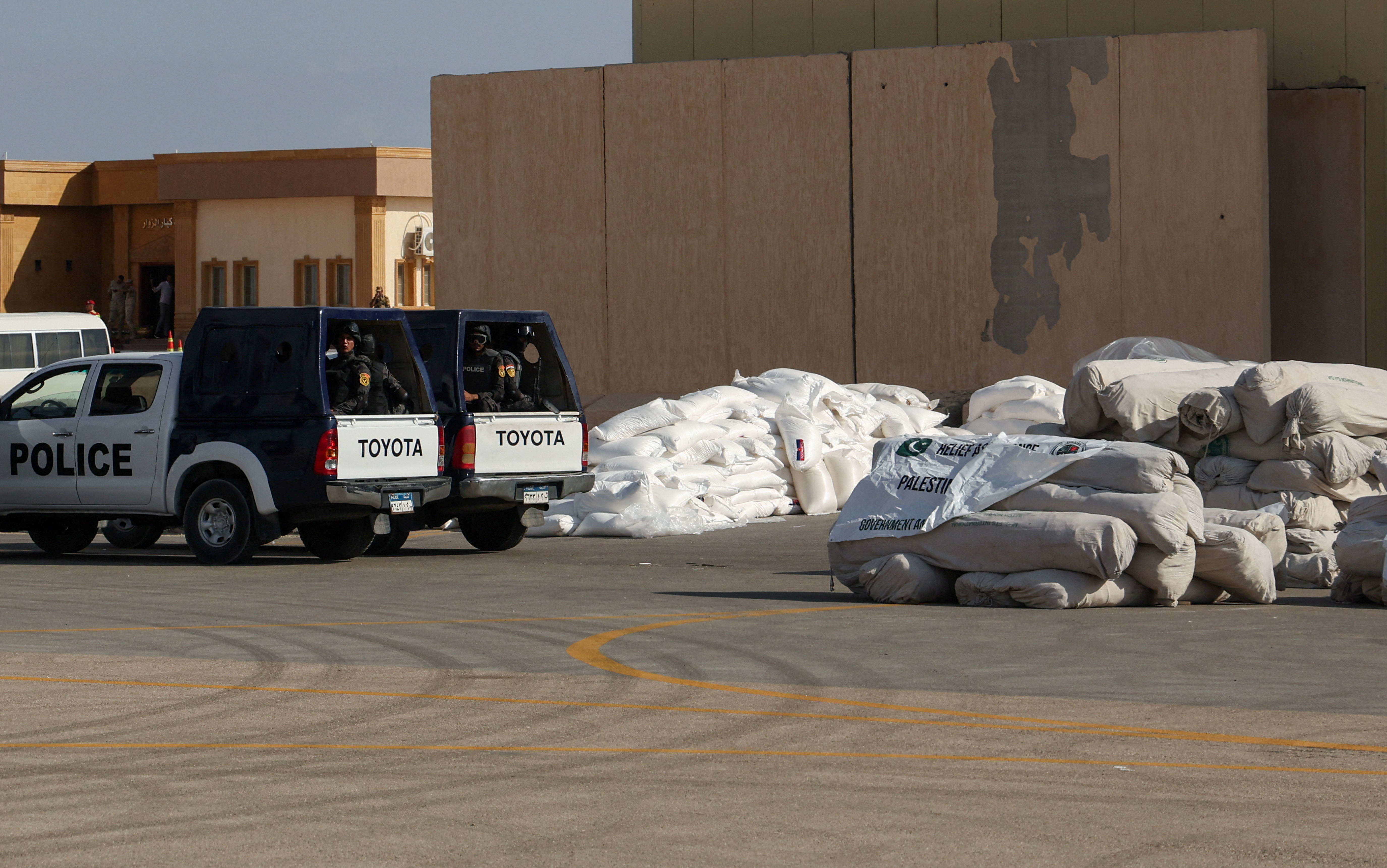 Egyptian police officers sit in vehicles next to humanitarian aid for Palestinians as it waits for the reopening of the Rafah border crossing. /Amr Abdallah Dalsh/Reuters