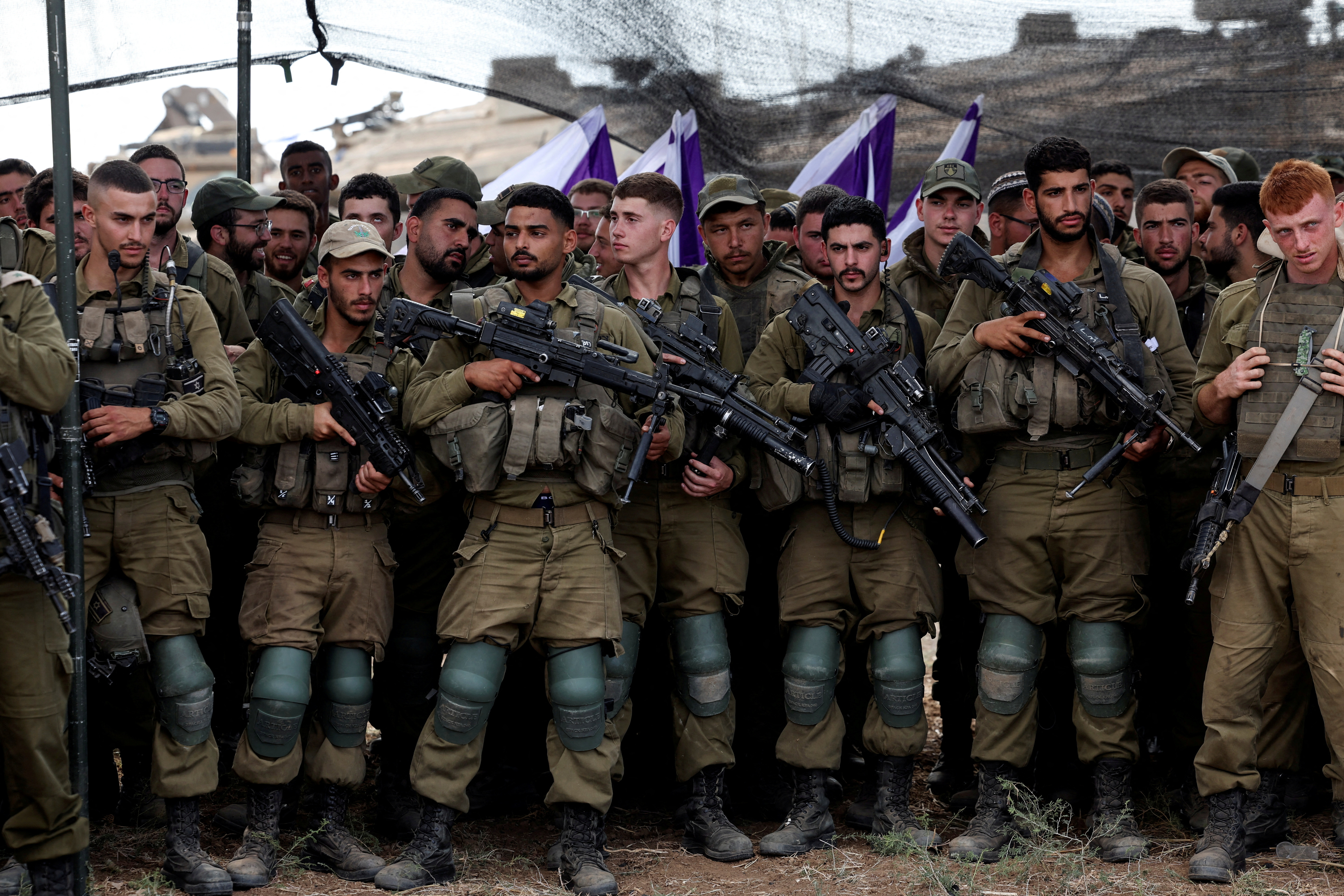 Israeli soldiers listen to Defense Minister Yoav Gallant as he meets them in a field near the border with the Gaza Strip. /Ronen Zvulun/Reuters