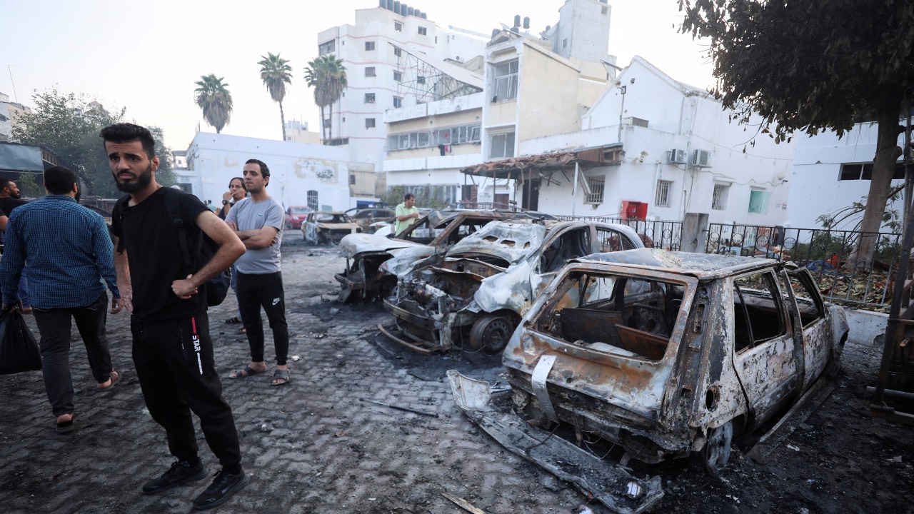 People inspect the area of Al Ahli hospital where hundreds of Palestinians were killed in a blast that Israeli and Palestinian officials blamed on each other. /Mohammed Al-Masri/Reuters