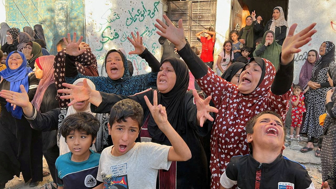 Palestinians react at the site of an Israeli strike on a house in Gaza City. /Mutasem Murtaja/Reuters