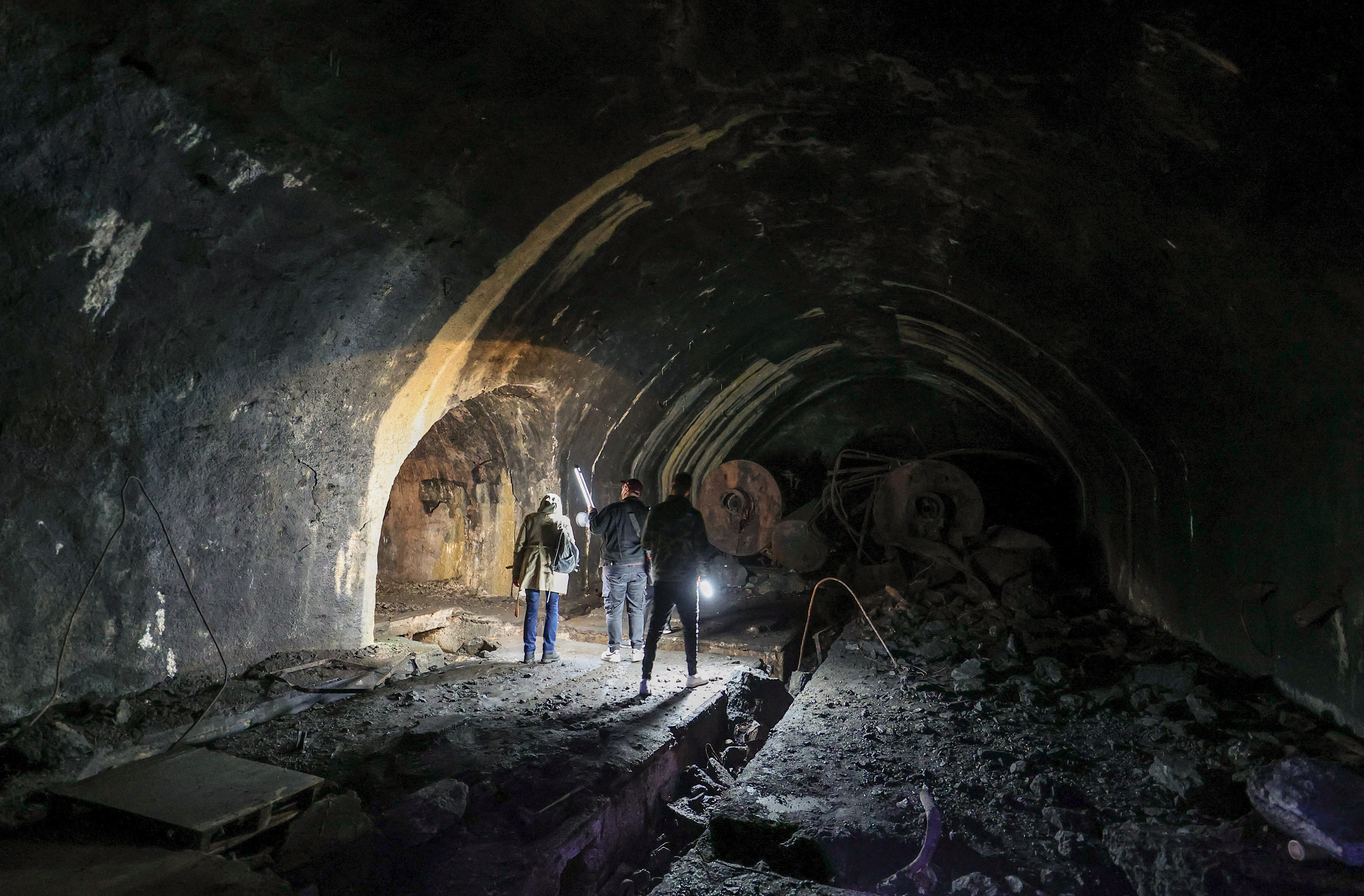 Visitors flashlights as they walk inside a dark tunnels at the Zeljava underground army airbase. /Damir Sencar/AFP