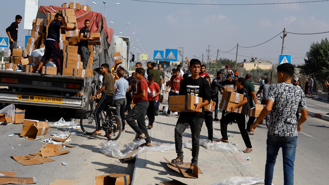 Palestinians reload an aid truck with aid boxes that fell from the truck, amid shortages of food supplies in Rafah in the southern Gaza Strip. /Ibraheem Abu Mustafa
