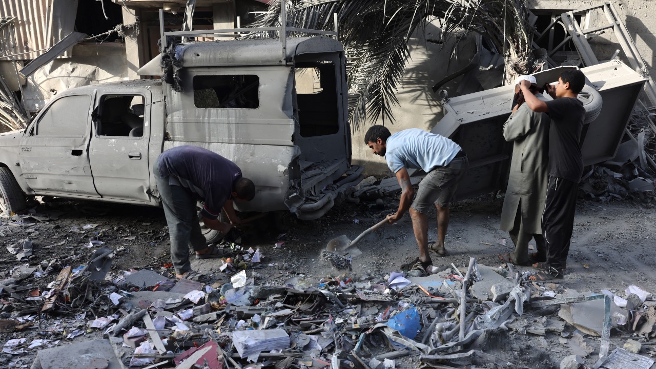 Palestinians clean debris after an Israeli bombardment in Rafah in the southern Gaza Strip. /Mohammed Abed/AFP