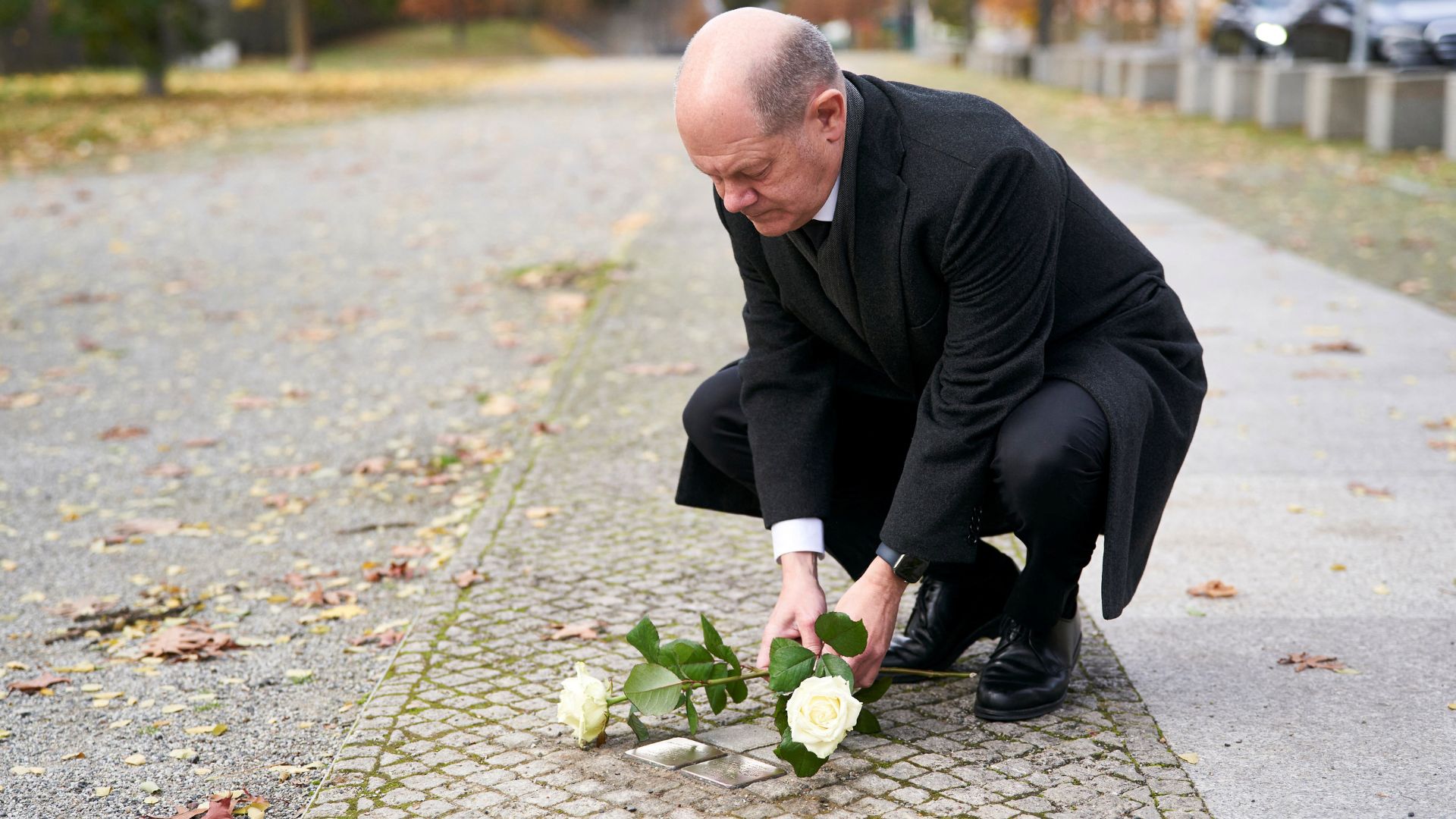 Scholz cleans Stumbling Stones (Stolpersteine) to commemorate Holocaust victims Hans Goslar und Ruth Judith Goslar near the chancellery in Berlin. /Henning Schacht/Bundesregierung/Handout via Reuters