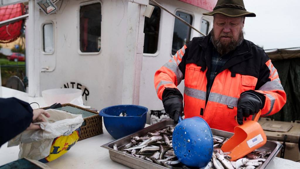 Fisherman Matti Kukkola sells fish from the boat during the fish market in Helsinki, Finland. /Alessandro Rampazzo/AFP