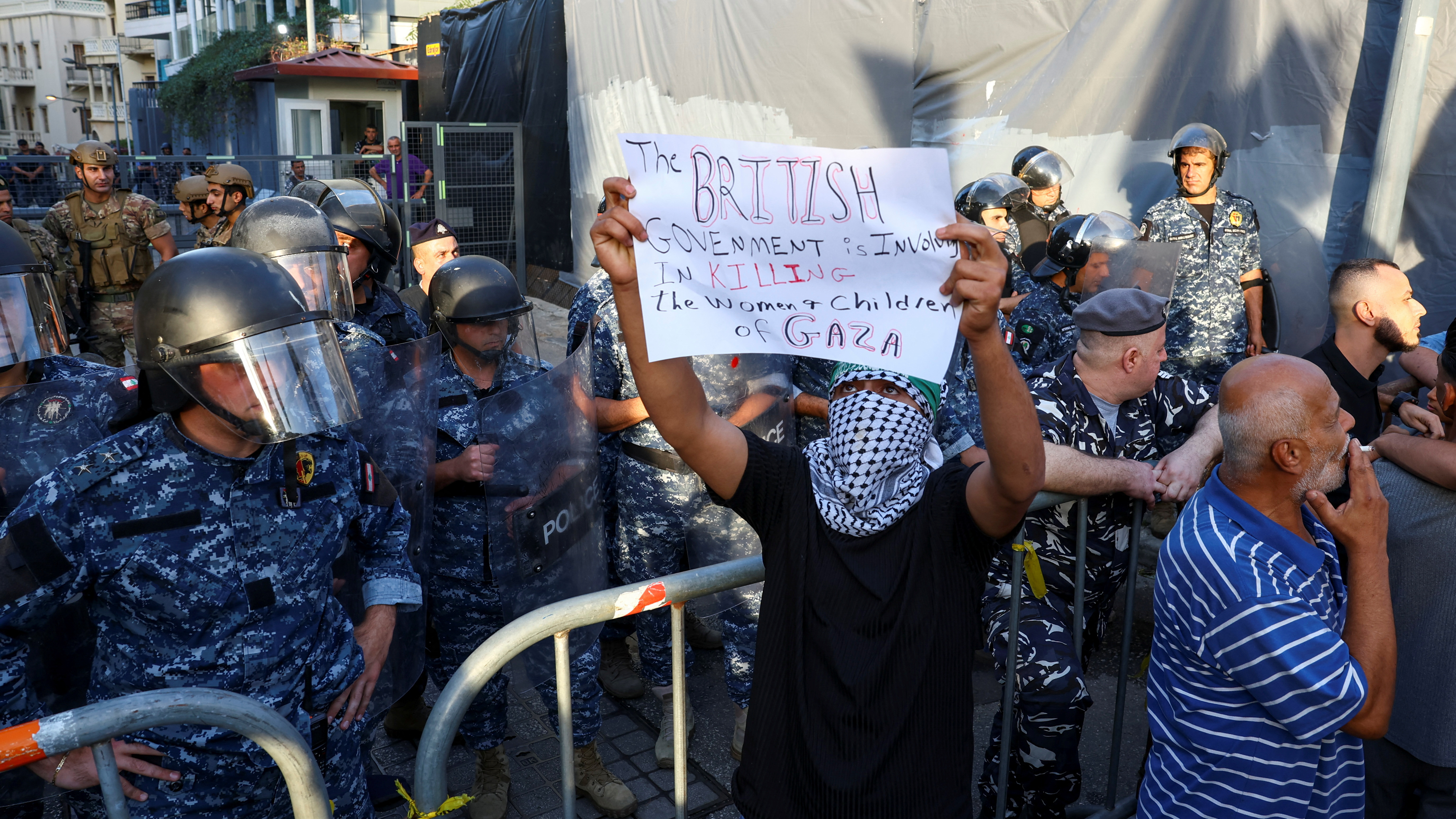 Demonstrators take part in a protest in support of Palestinians in Gaza as police stand guard near the British embassy in Beirut, Lebanon. /Esa Alexander/Reuters