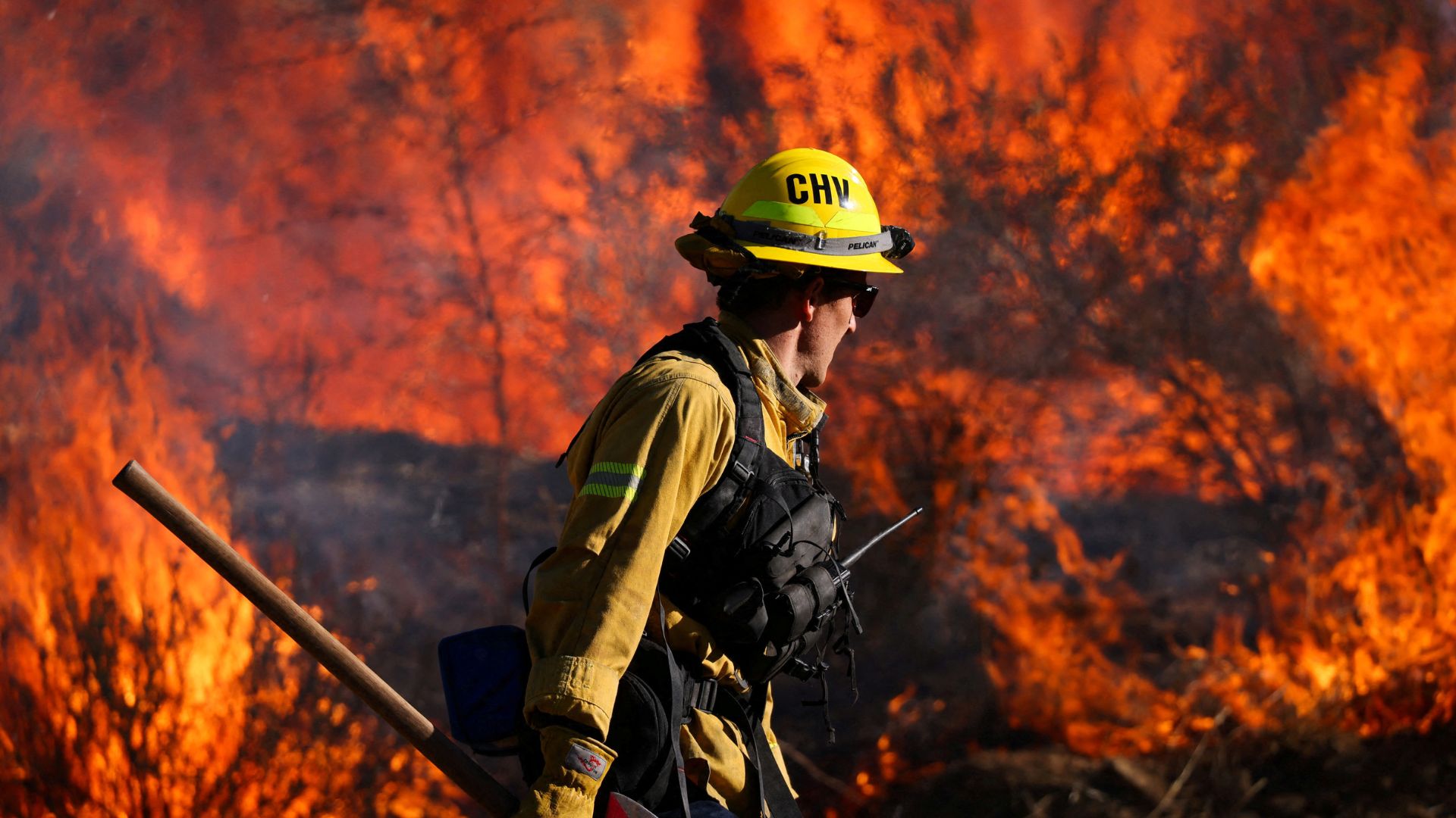 A firefighter works to extinguish the Highland Fire, a wind driven wildfire near Aguanga, California on October 31. /Mike Blake/Reuters 