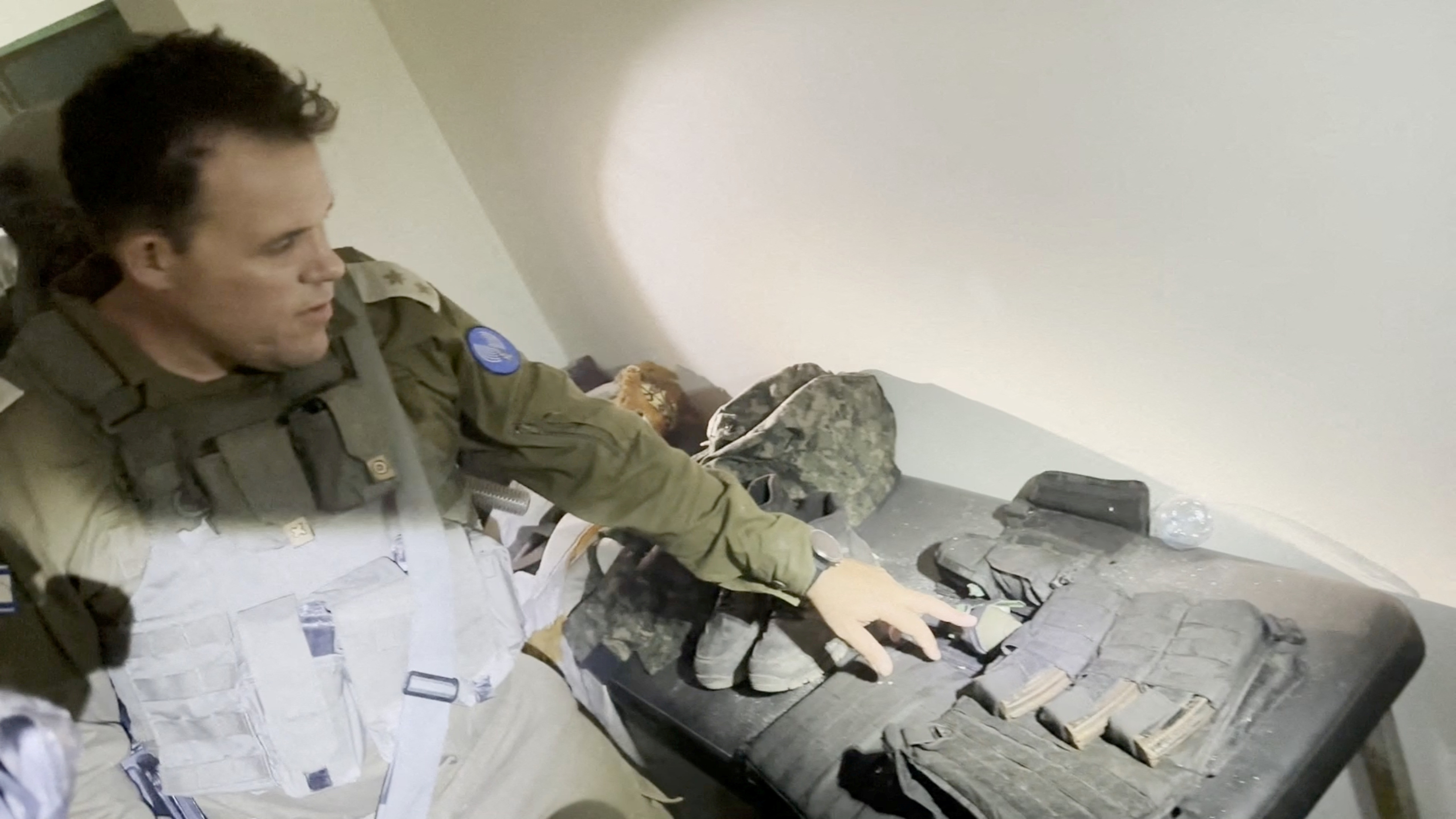 An Israeli soldier points at what the IDF says is a cache of Hamas weapons found inside Al Shifa hospital. /IDF/Reuters