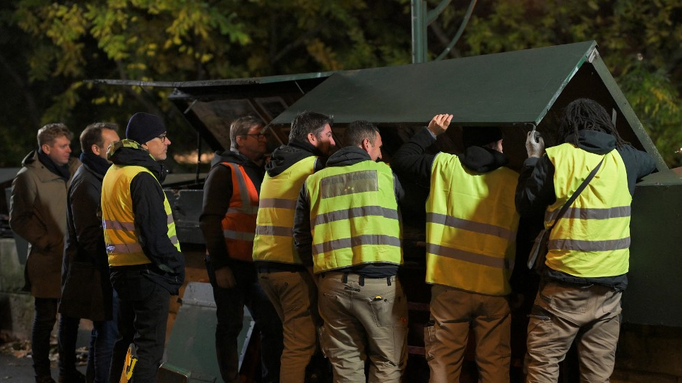 Ordered by the Paris Police Prefecture, the City of Paris is dismantling and reassembling the booksellers boxes situated on the route of the opening ceremony of the 2024 Olympic Games. /Miguel Medina/AFP